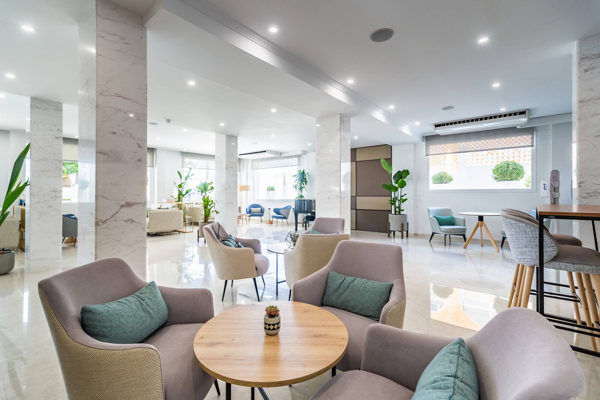 Bright hotel lobby lounge with contemporary seating and marble details.