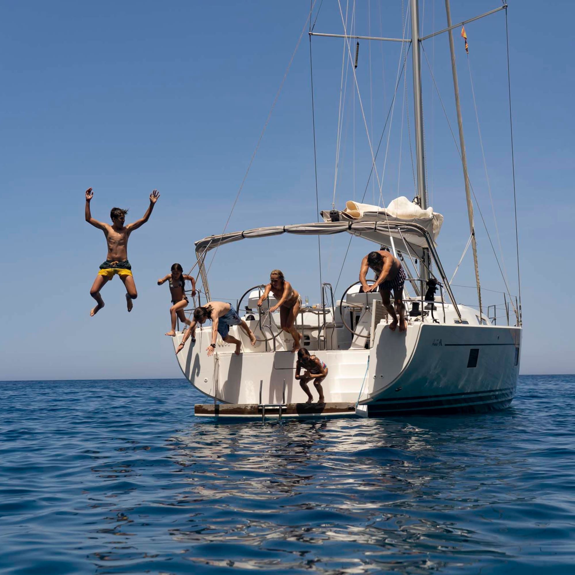 a group of people jumping off a boat