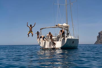 a group of people jumping off a boat