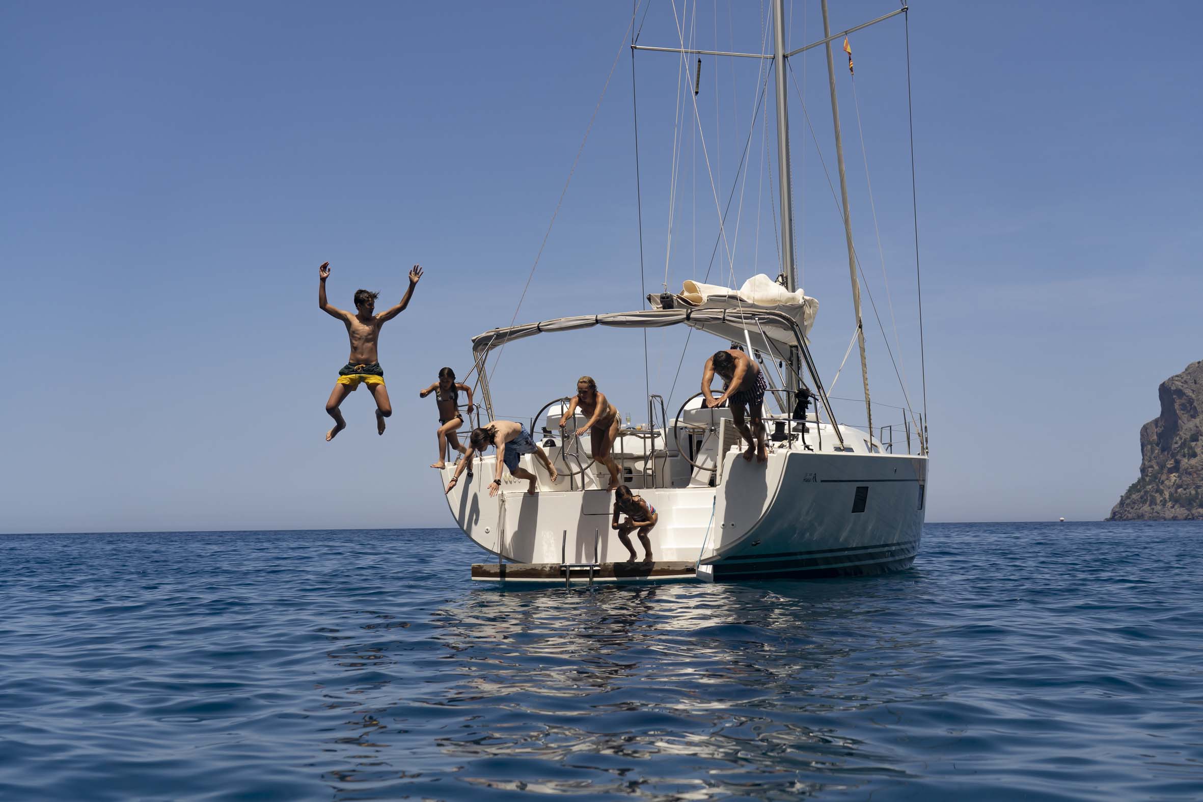 a group of people jumping off a boat