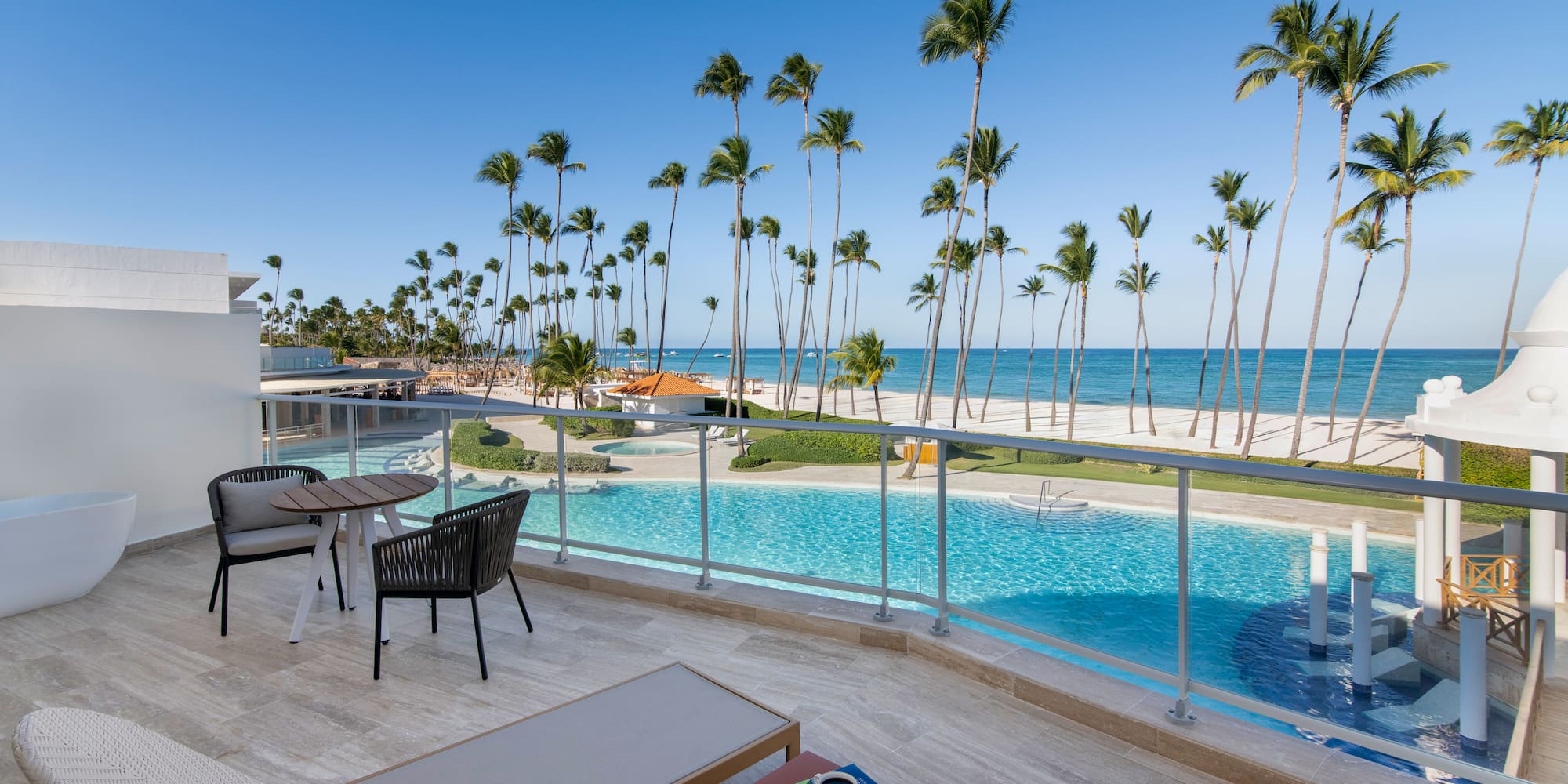 a pool with palm trees and a beach and a table