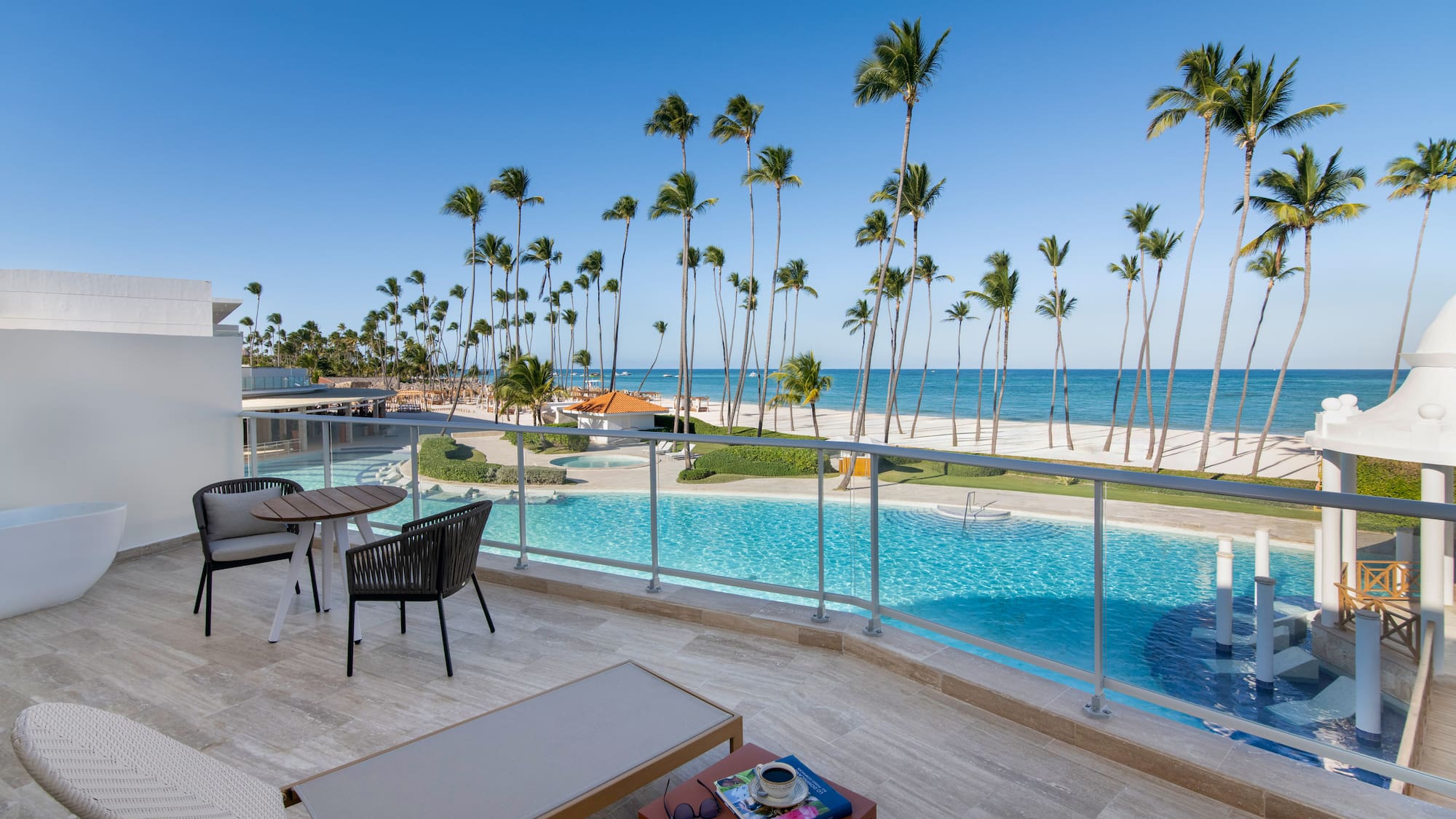 a pool with palm trees and a beach and a table