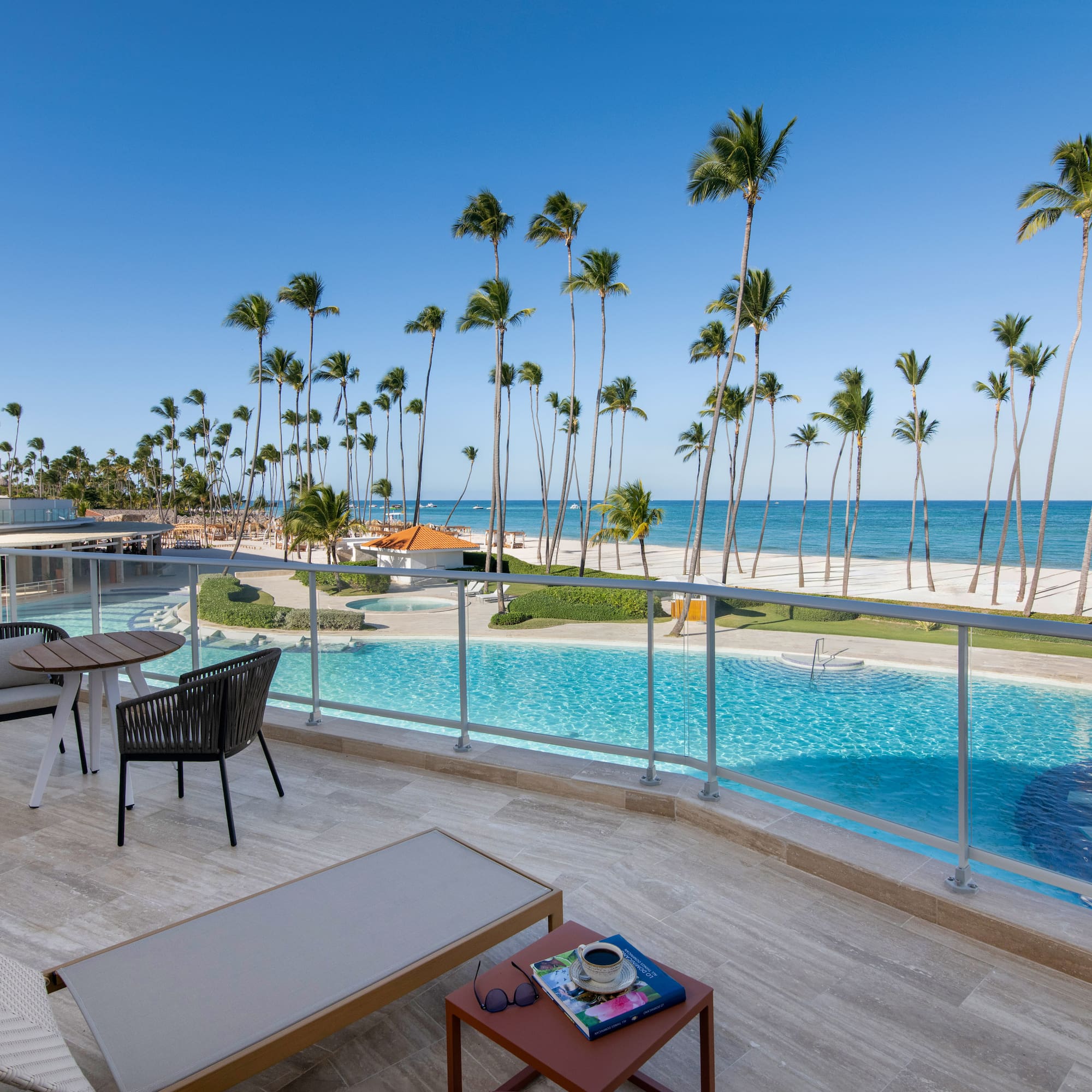 a pool with palm trees and a beach and a table
