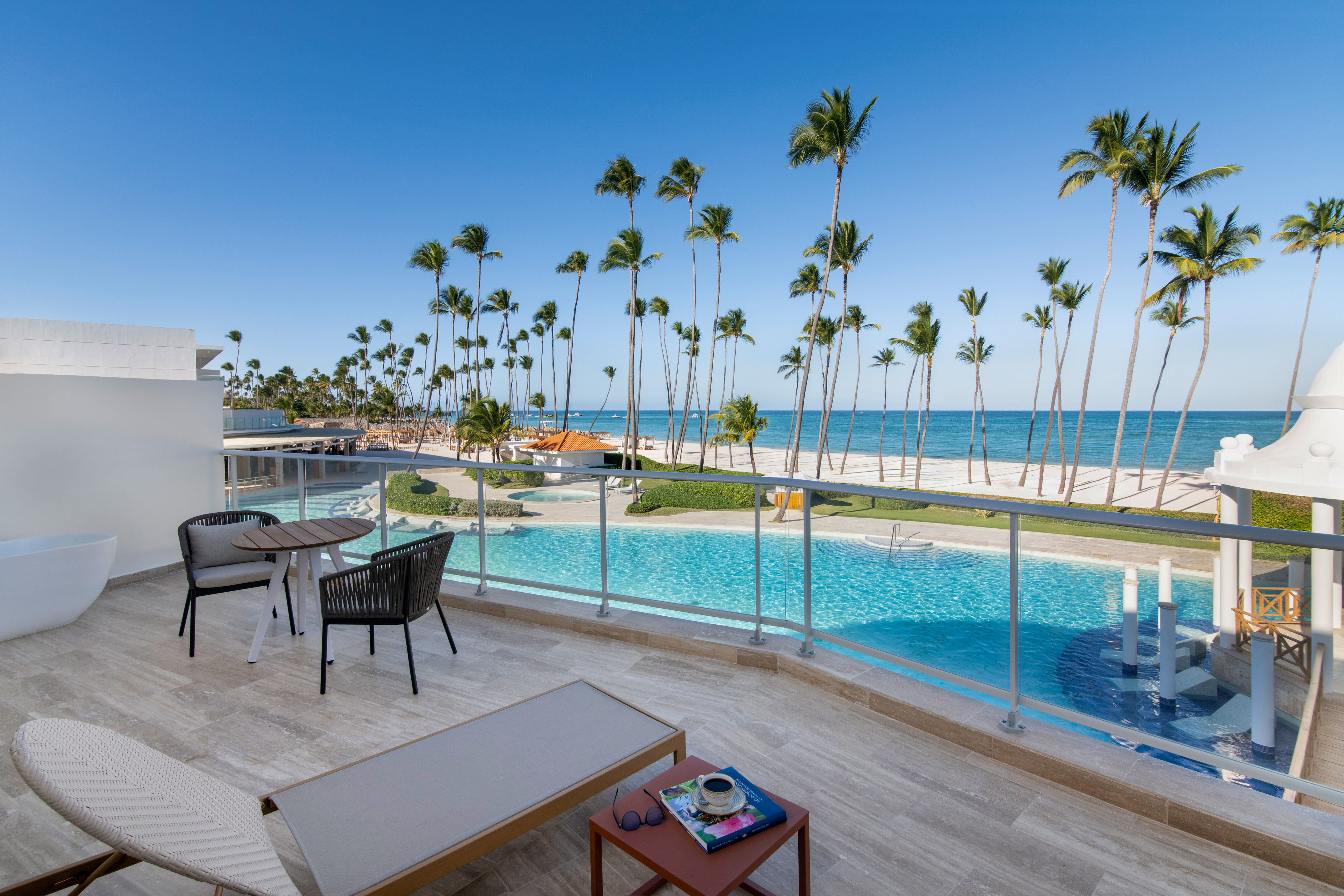 a pool with palm trees and a beach and a table