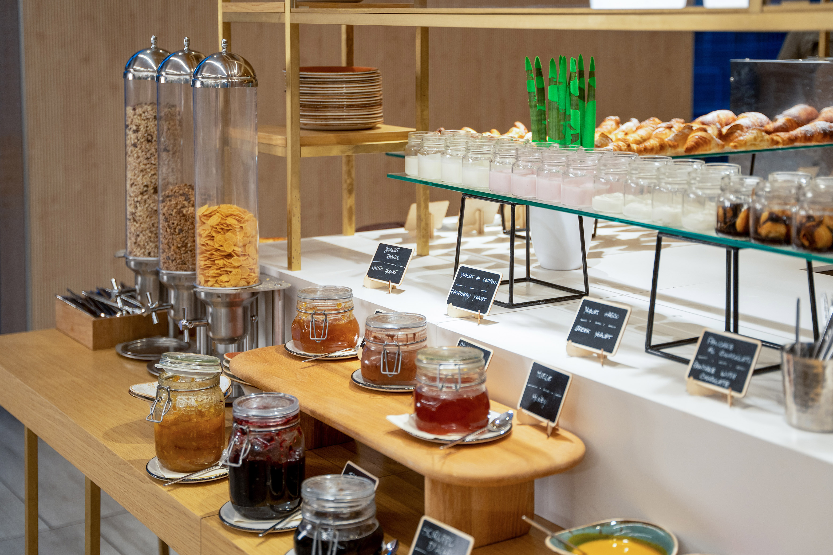 Hotel breakfast buffet: cereal, assorted jams, yogurts, and fresh croissants.