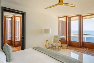 a room with a bed and a fan and a chair