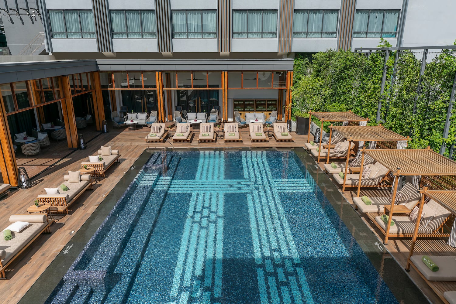 a pool with lounge chairs and a building