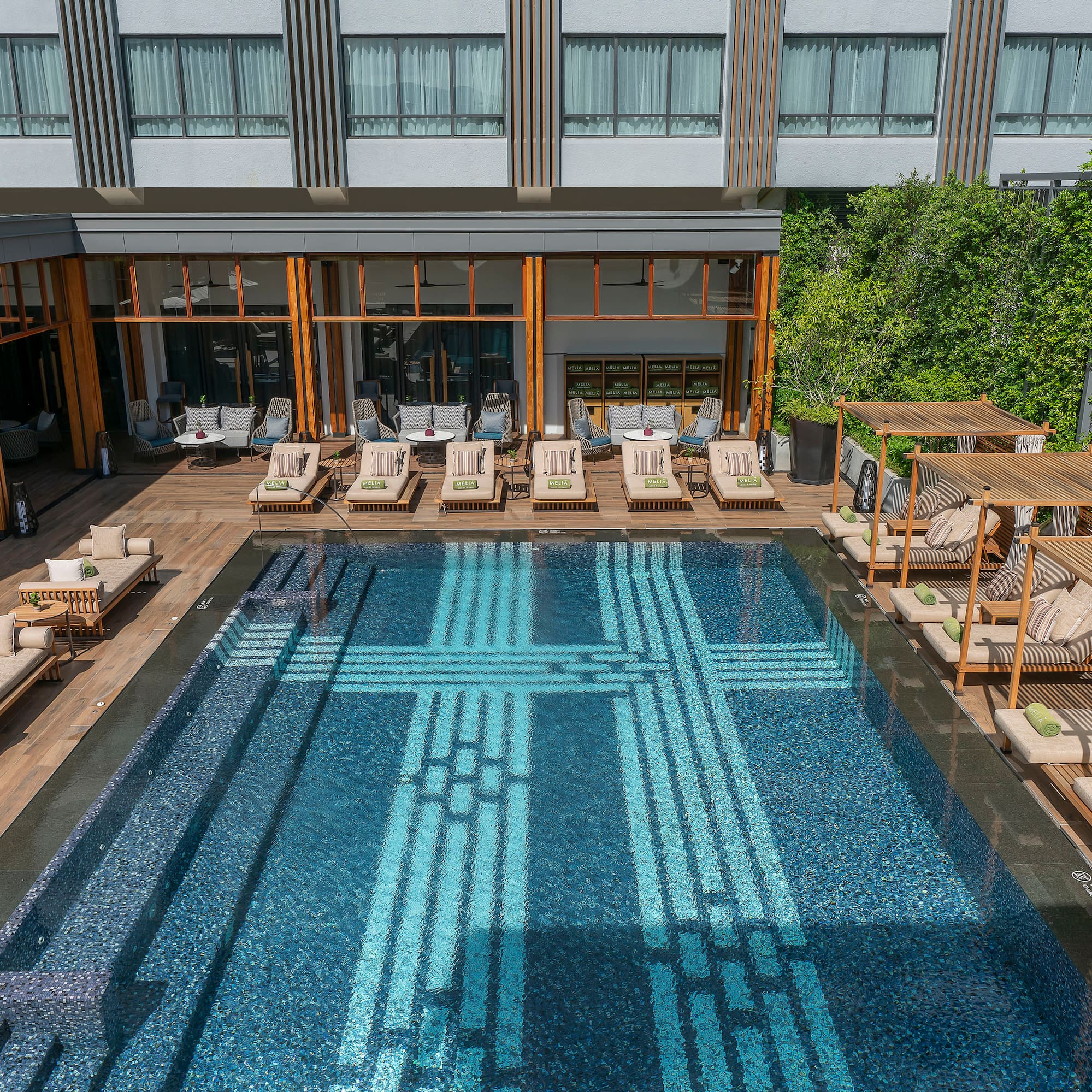 a pool with lounge chairs and a building
