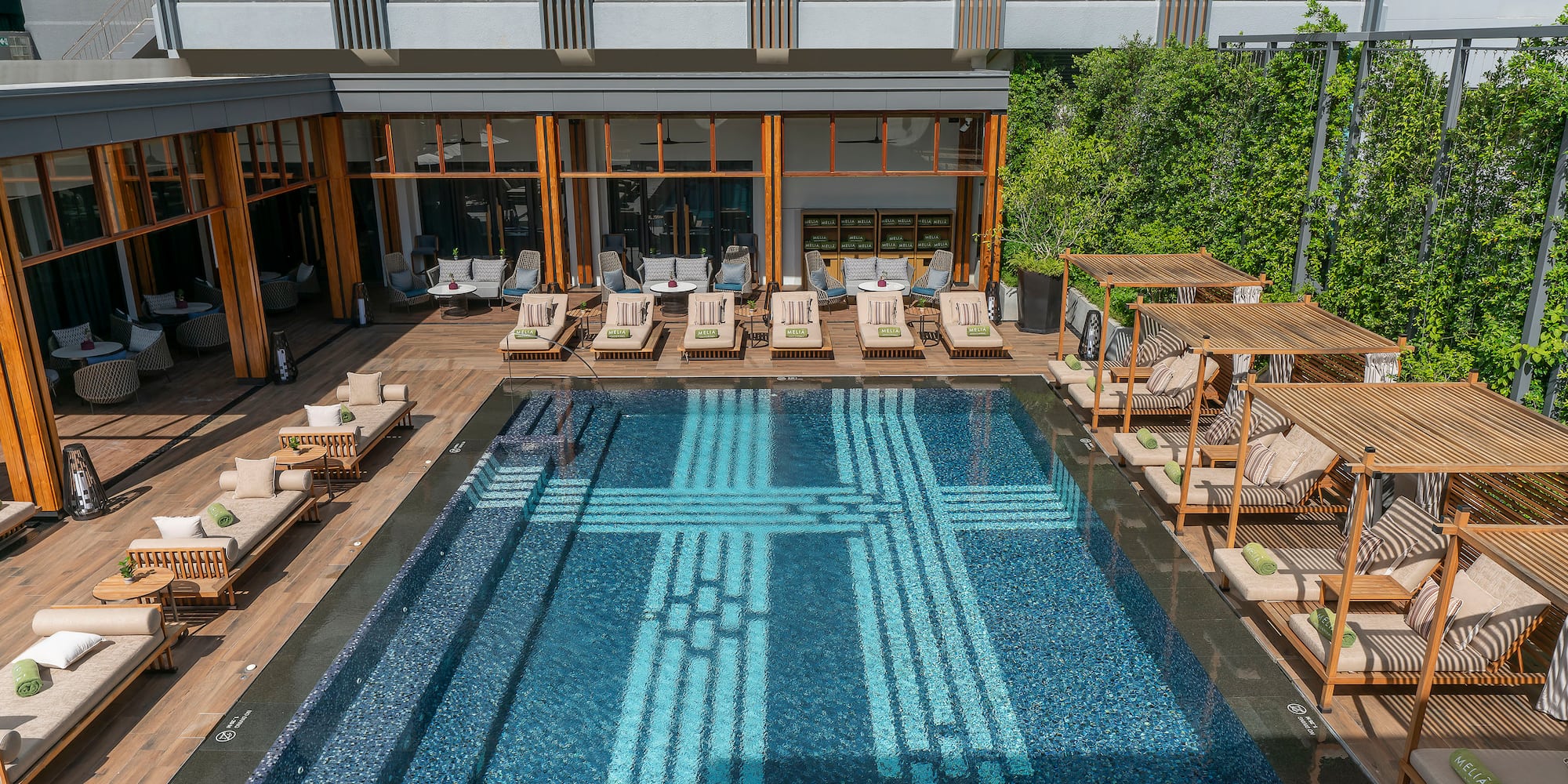 a pool with lounge chairs and a building