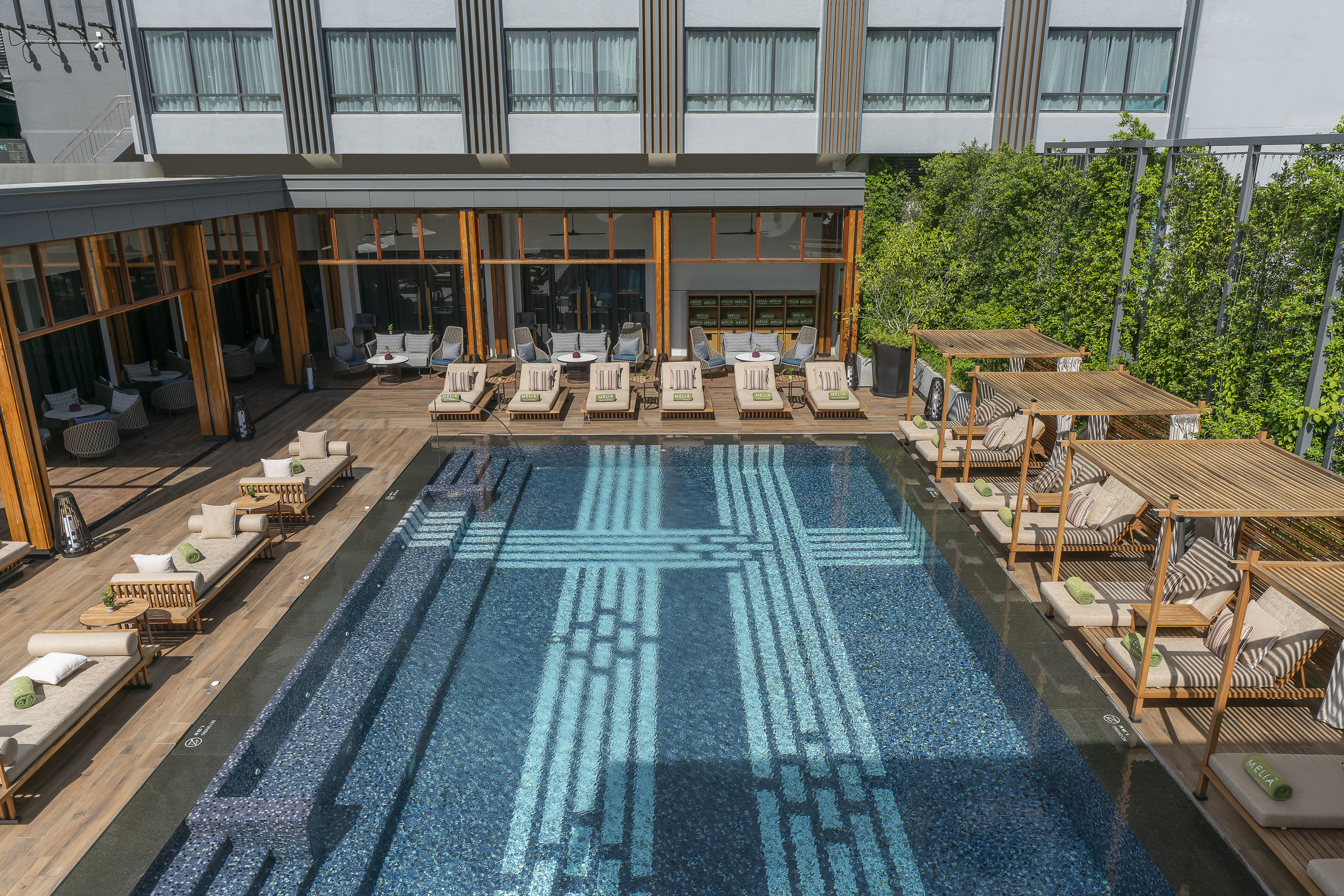 a pool with lounge chairs and a building
