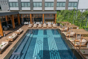 a pool with lounge chairs and a building