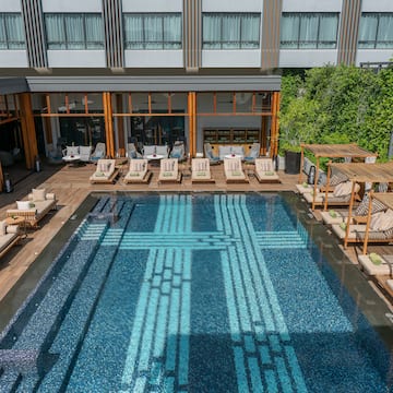 a pool with lounge chairs and a building