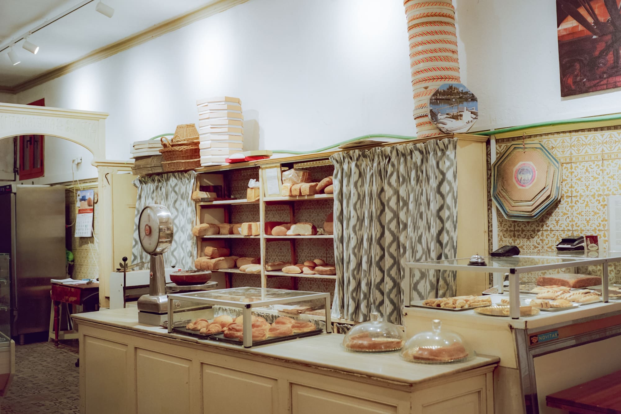 Panadería tradicional: mostrador, panes y bollería fresca en vitrinas.
