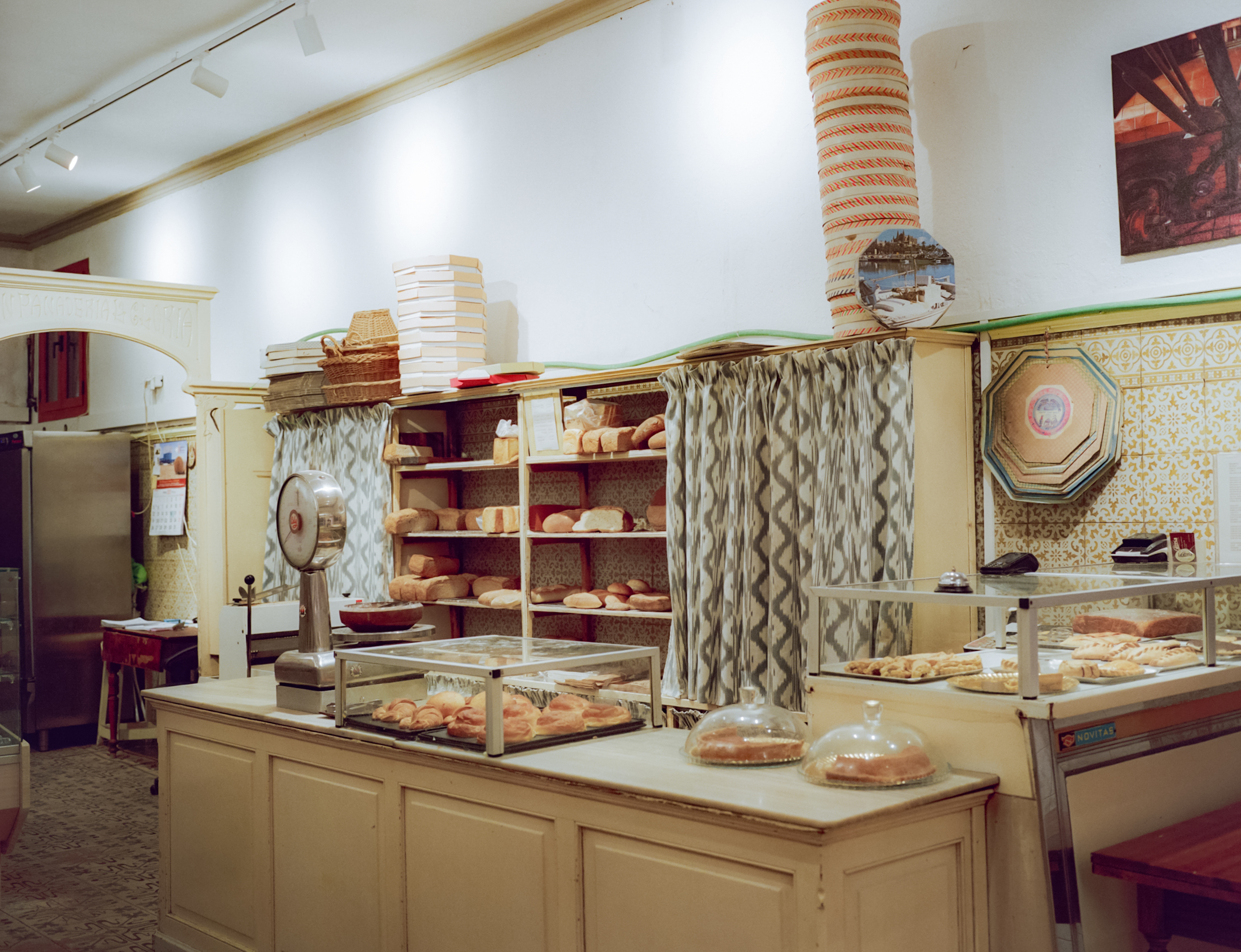 Panadería tradicional: mostrador, panes y bollería fresca en vitrinas.