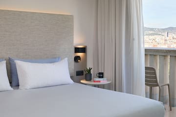 a bed with a headboard and a coffee cup on a table