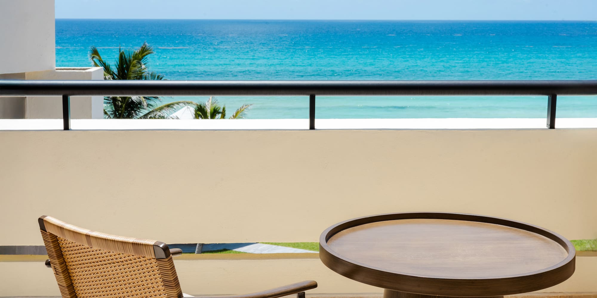 a table and chair on a balcony overlooking the ocean