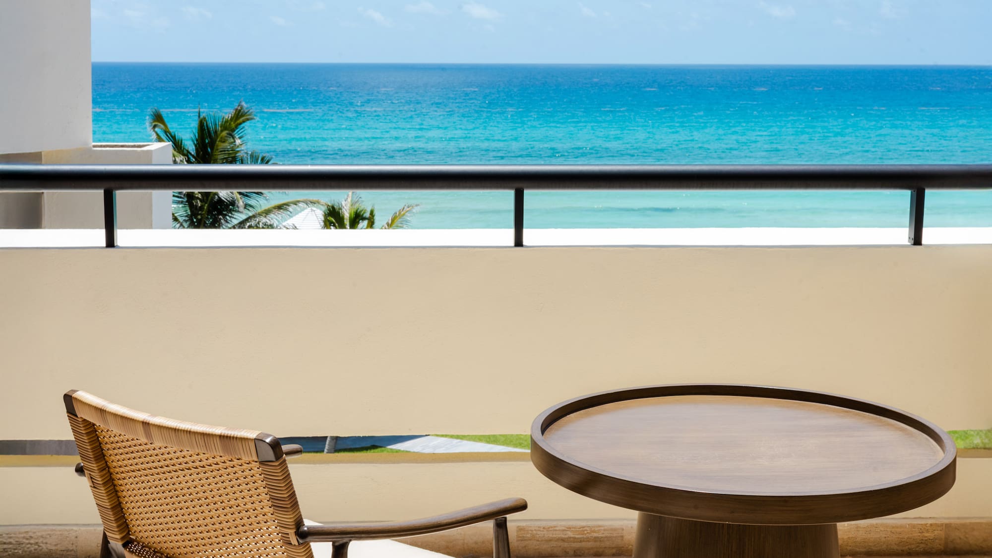 a table and chair on a balcony overlooking the ocean