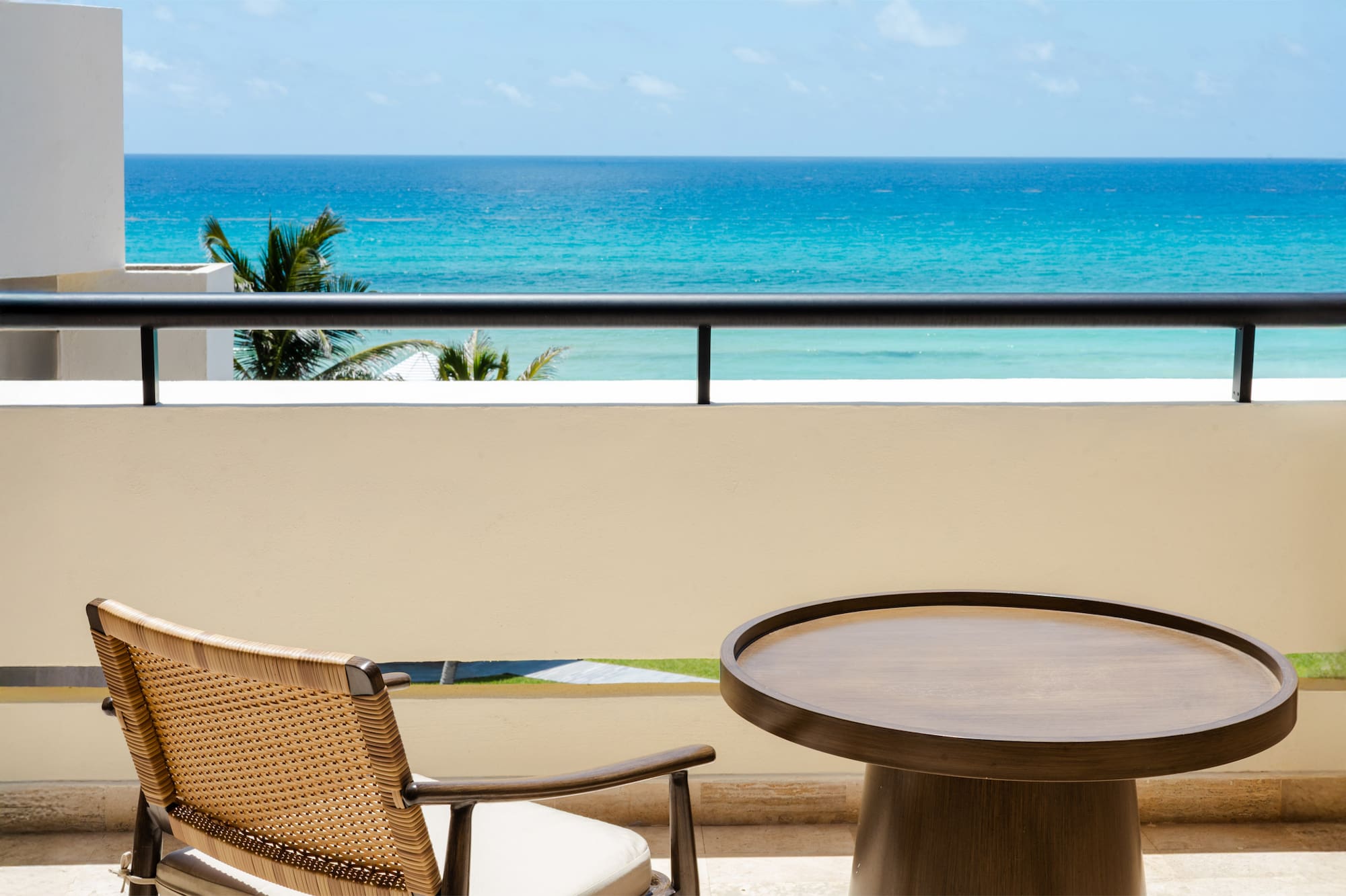 a table and chair on a balcony overlooking the ocean