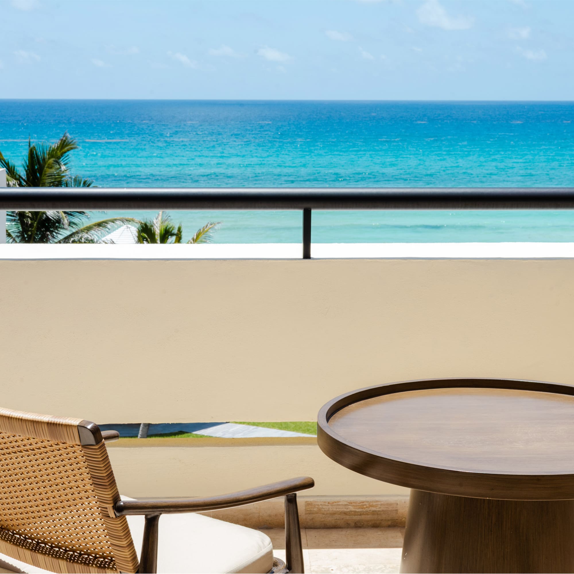 a table and chair on a balcony overlooking the ocean
