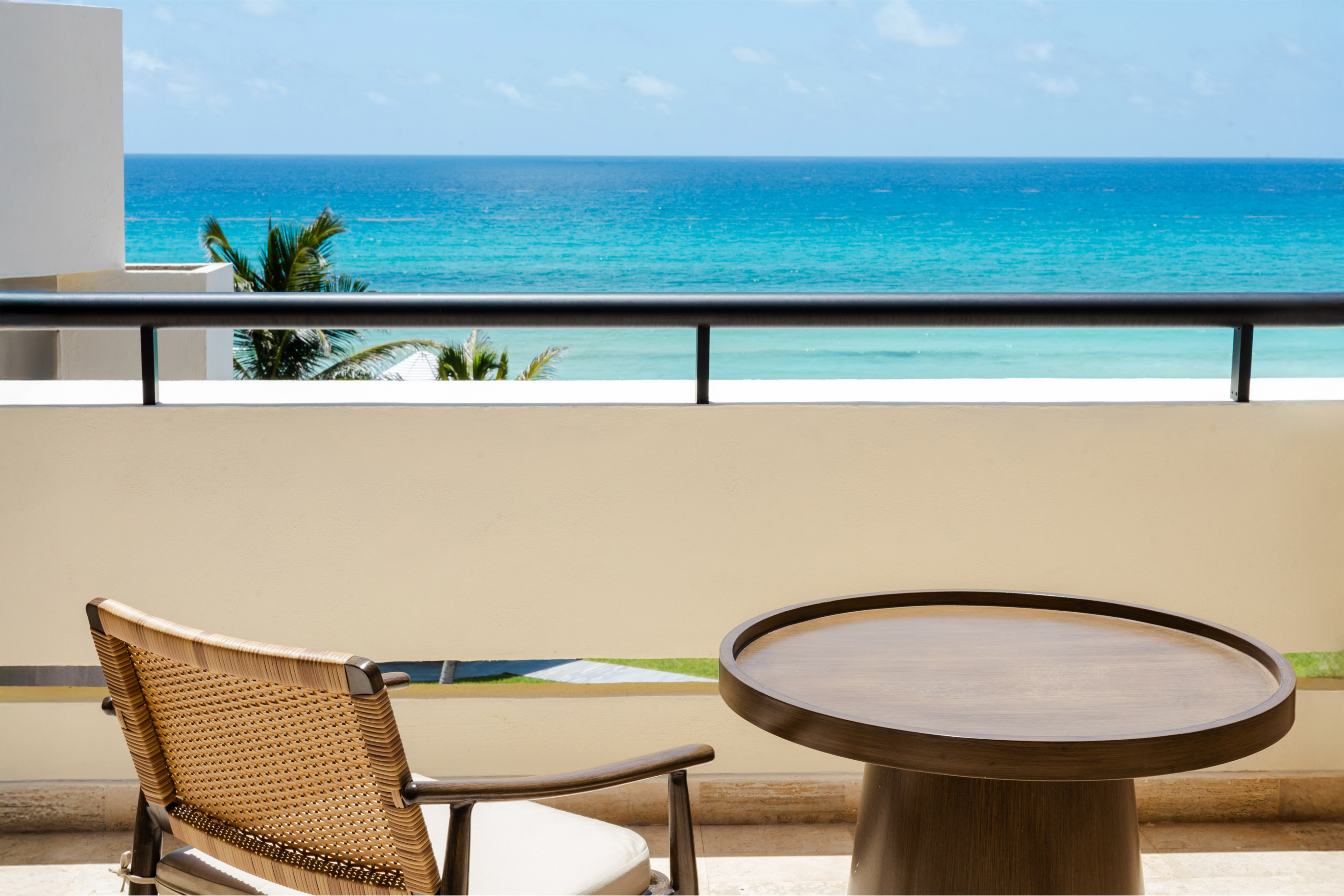 a table and chair on a balcony overlooking the ocean