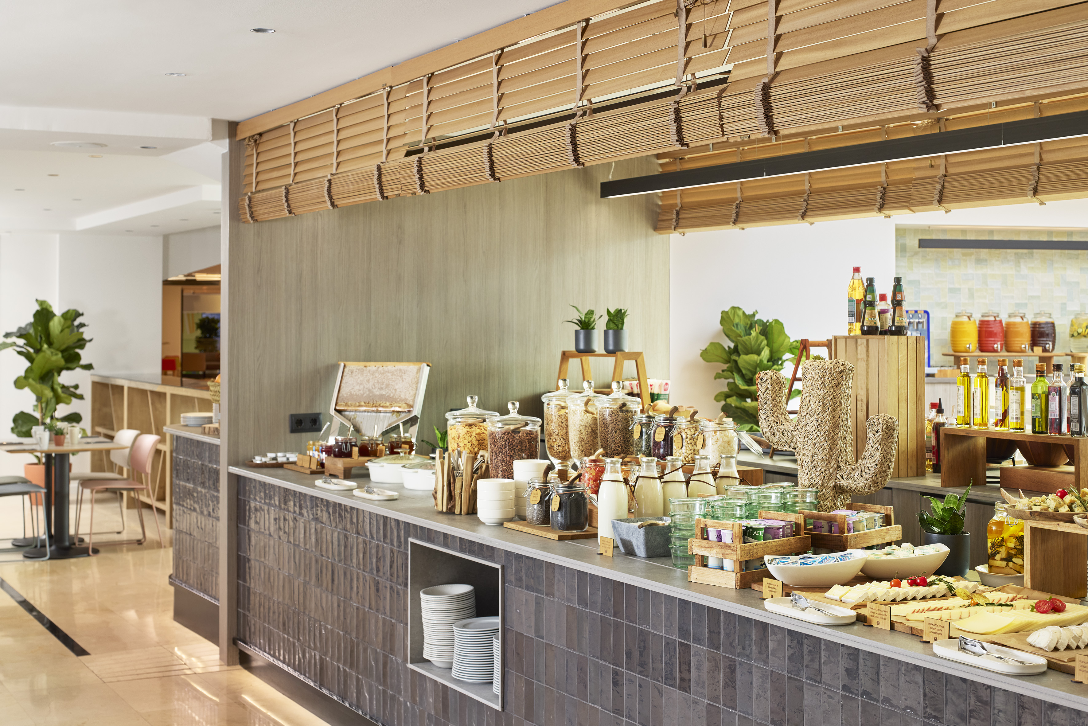 Modern hotel breakfast buffet with diverse cereals, fresh juices, and cheese.