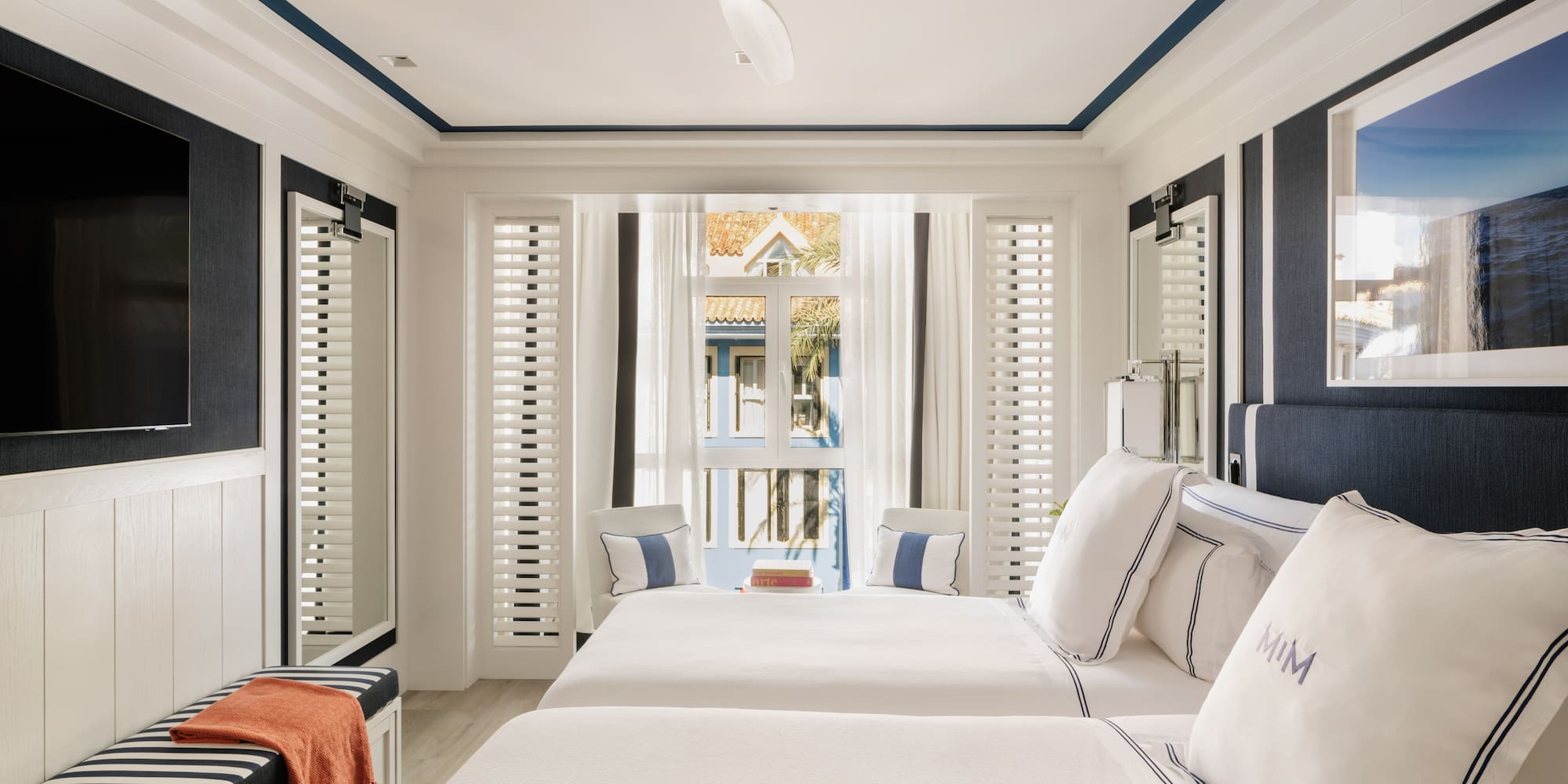 a room with two beds and a fan