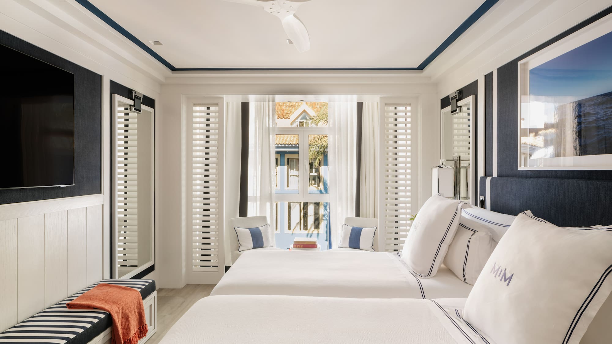 a room with two beds and a fan