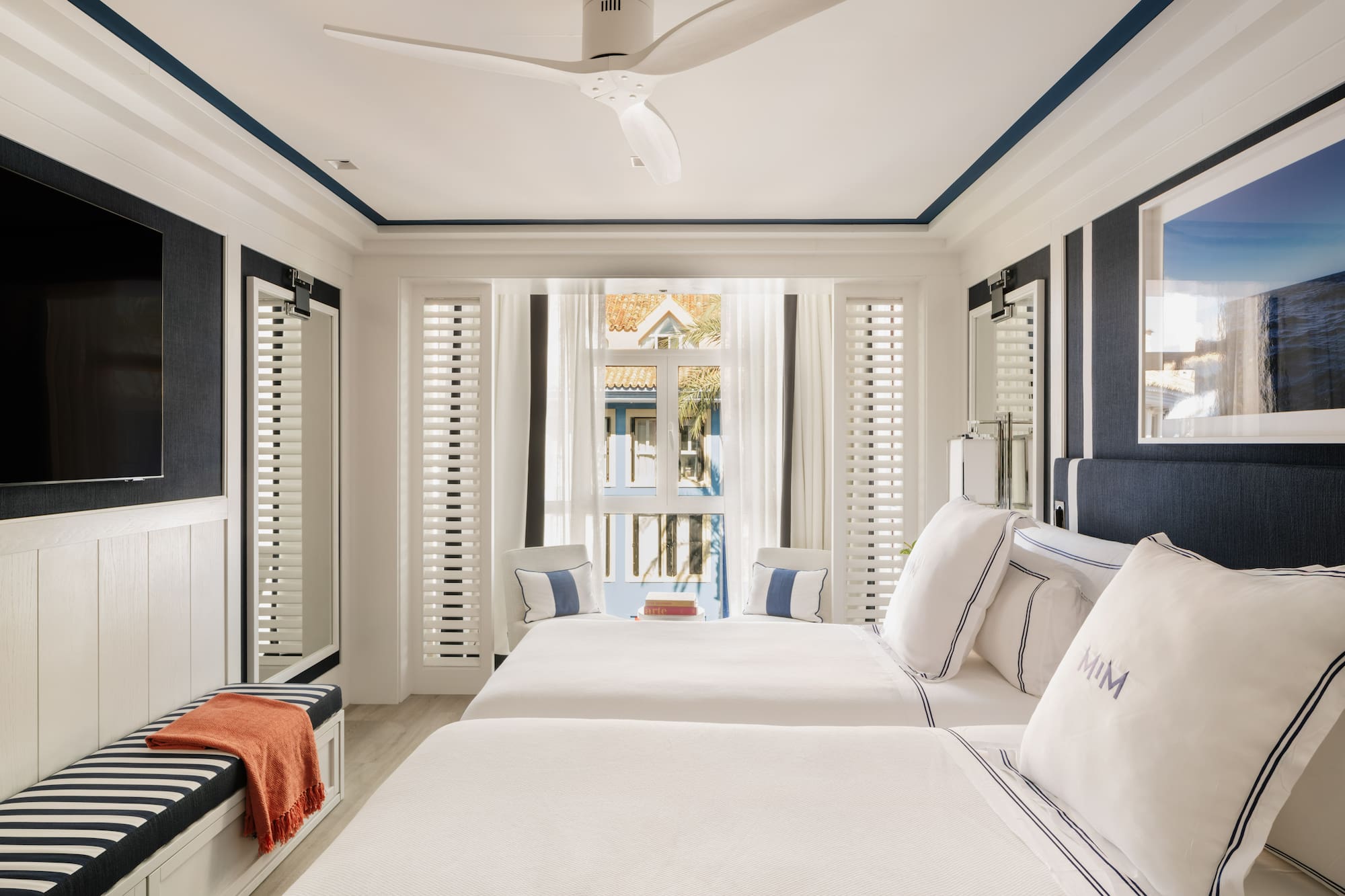 a room with two beds and a fan