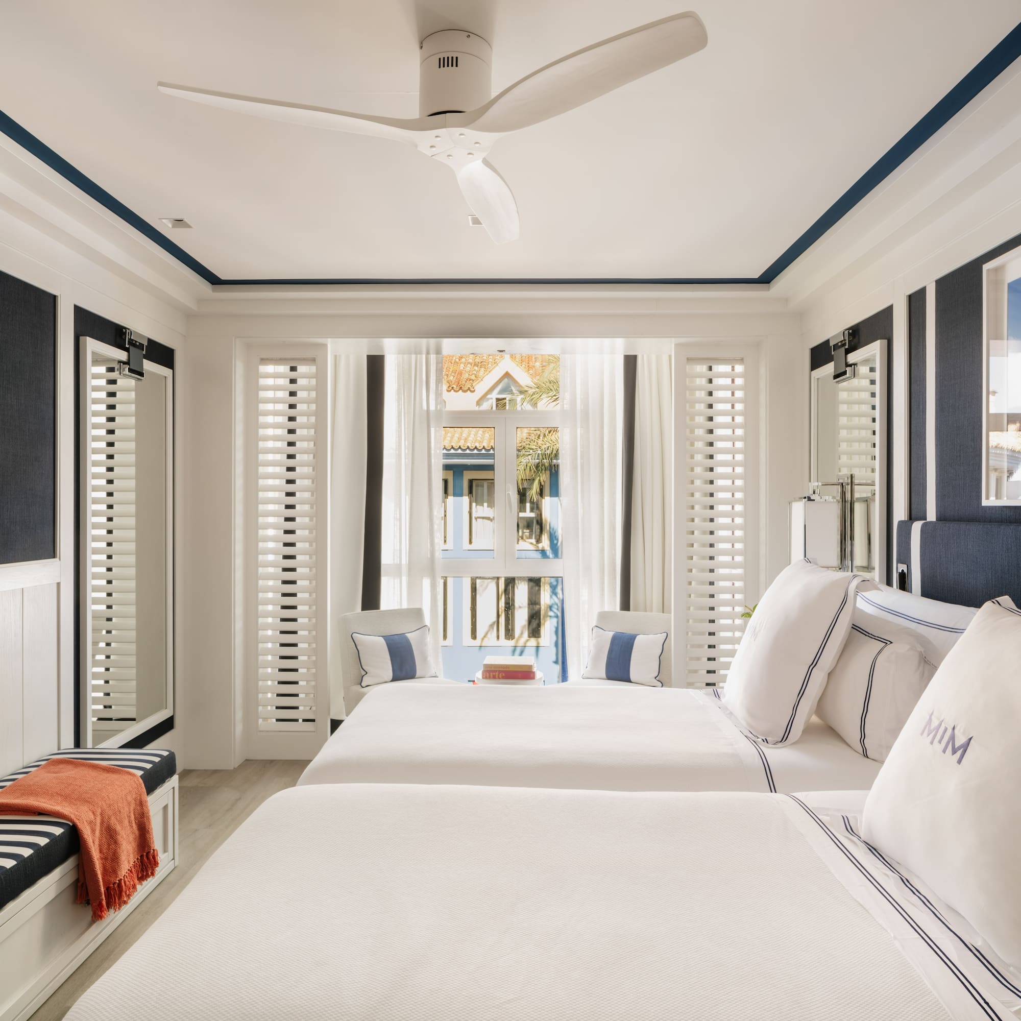 a room with two beds and a fan