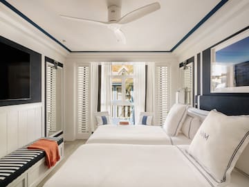a room with two beds and a fan