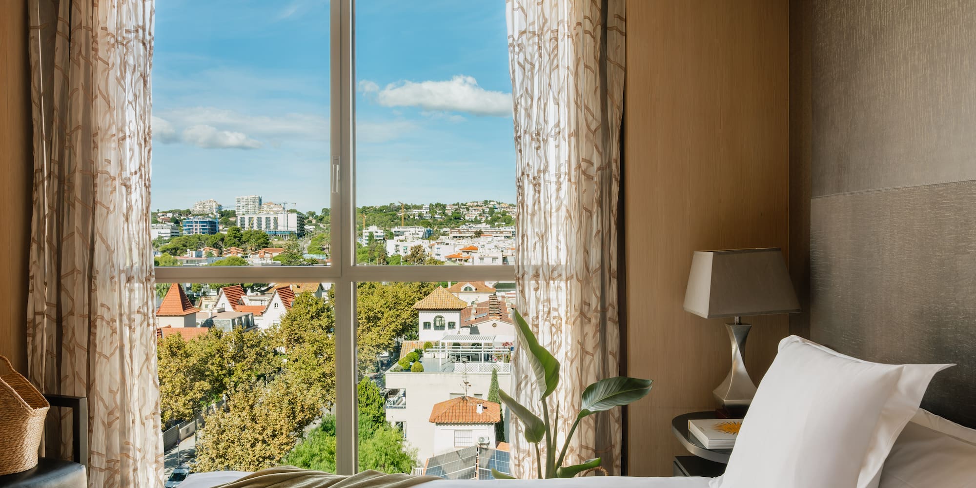 a bed with a window overlooking a city