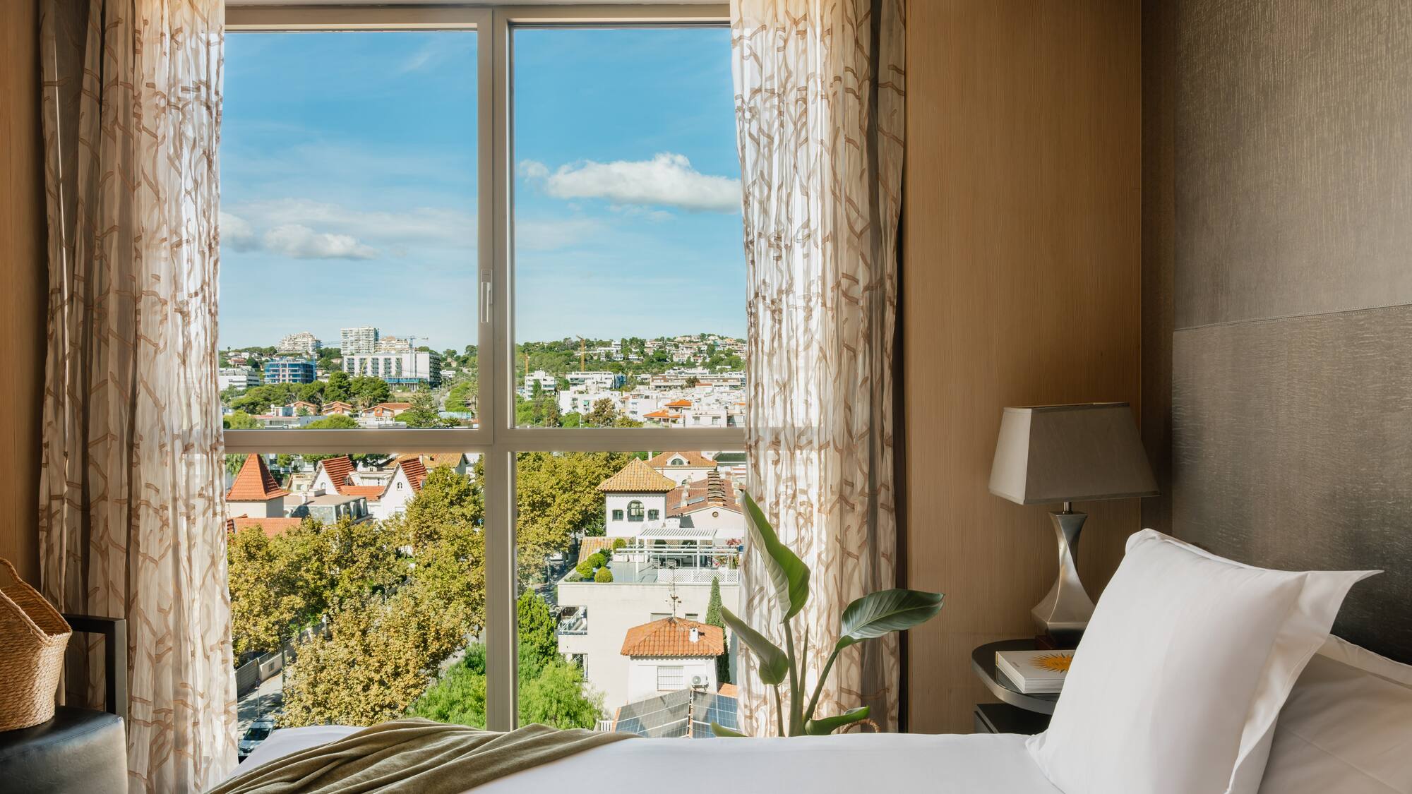 a bed with a window overlooking a city
