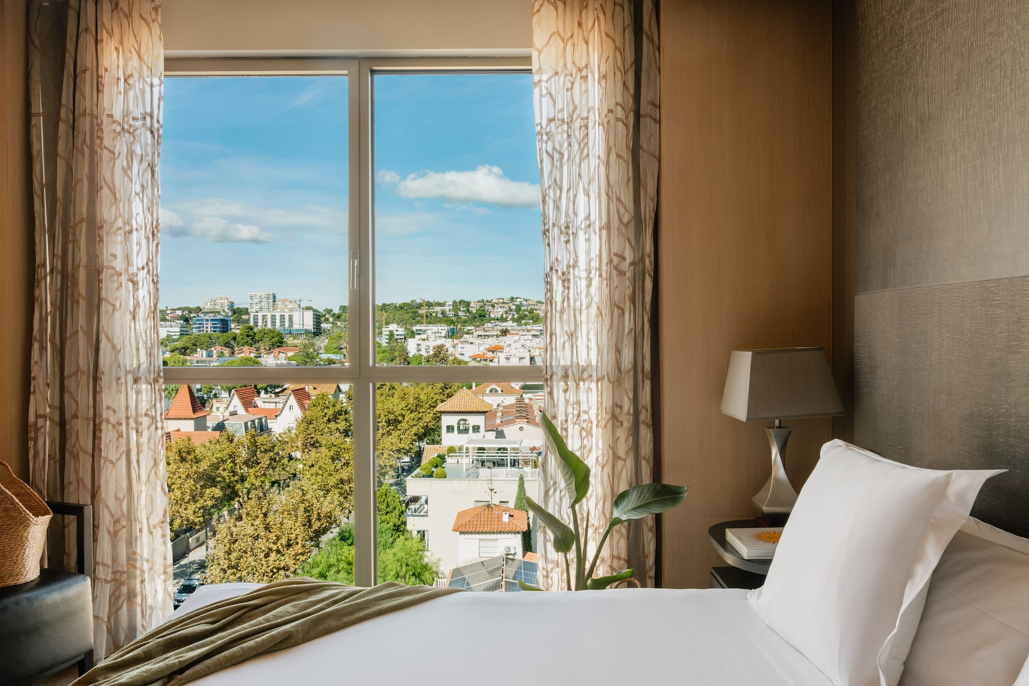 a bed with a window overlooking a city