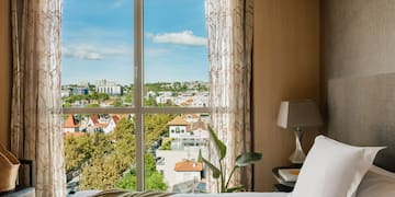 a bed with a window overlooking a city