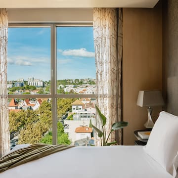 a bed with a window overlooking a city