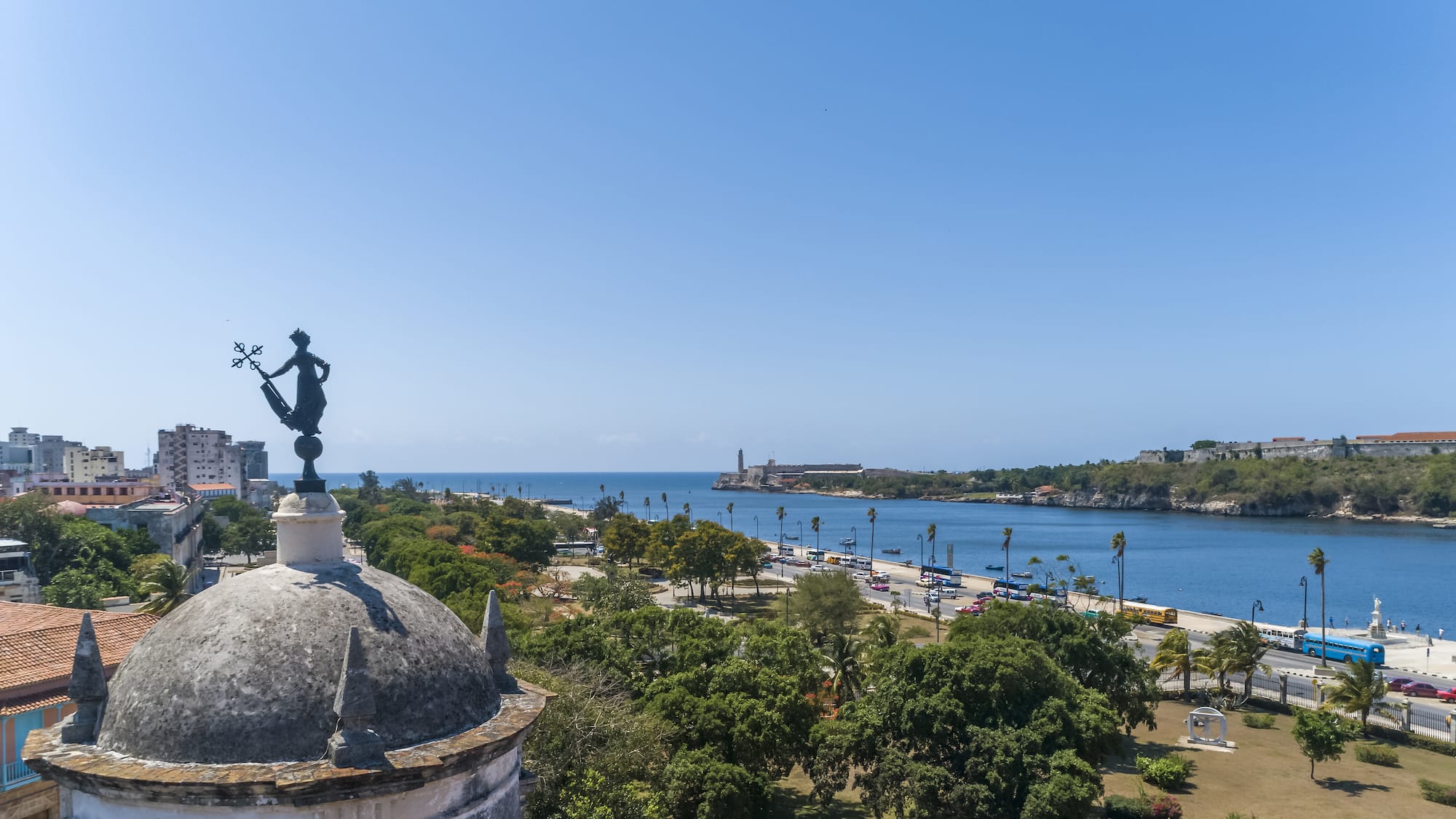 a city with a body of water and a statue on top