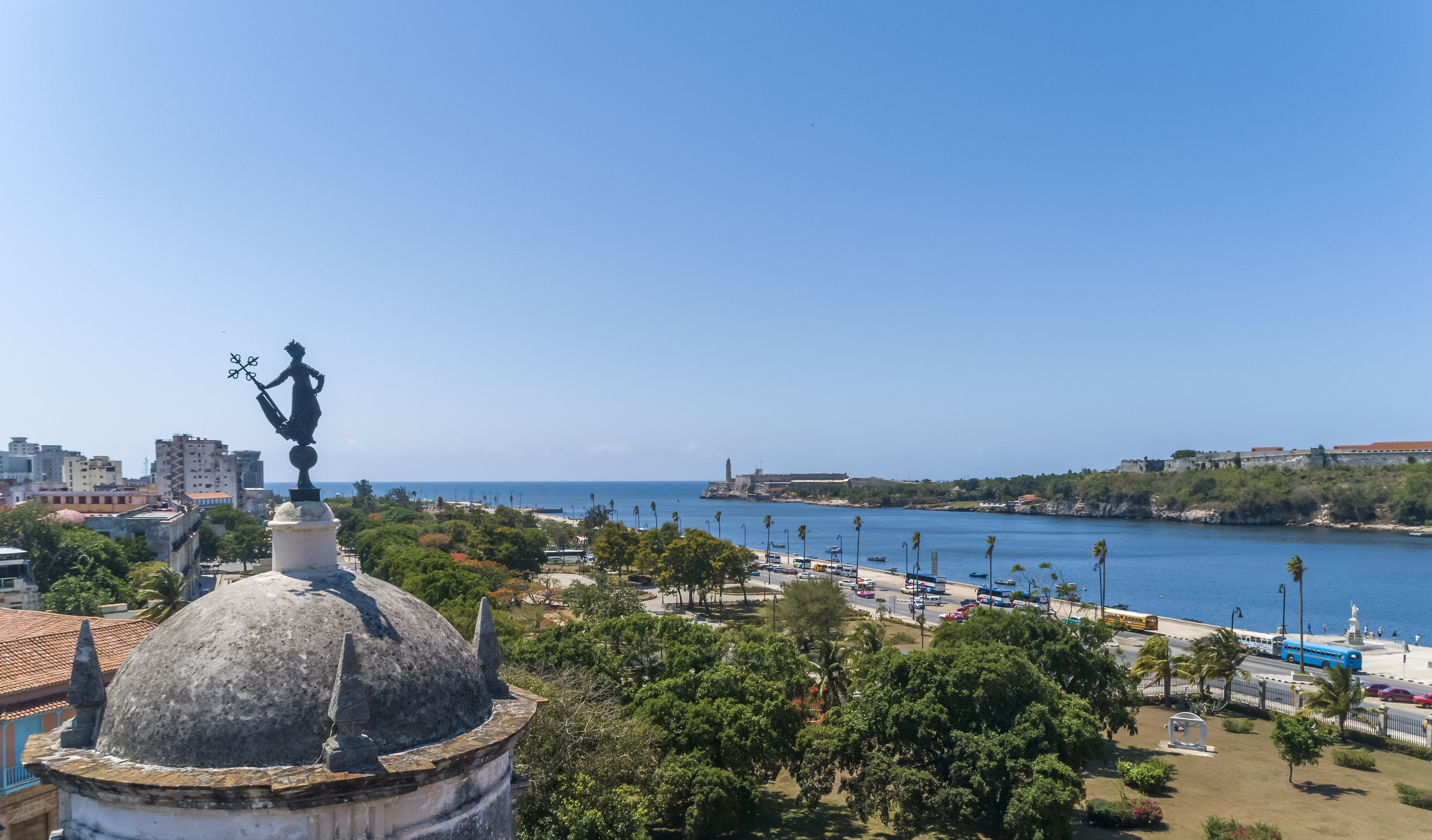 a city with a body of water and a statue on top