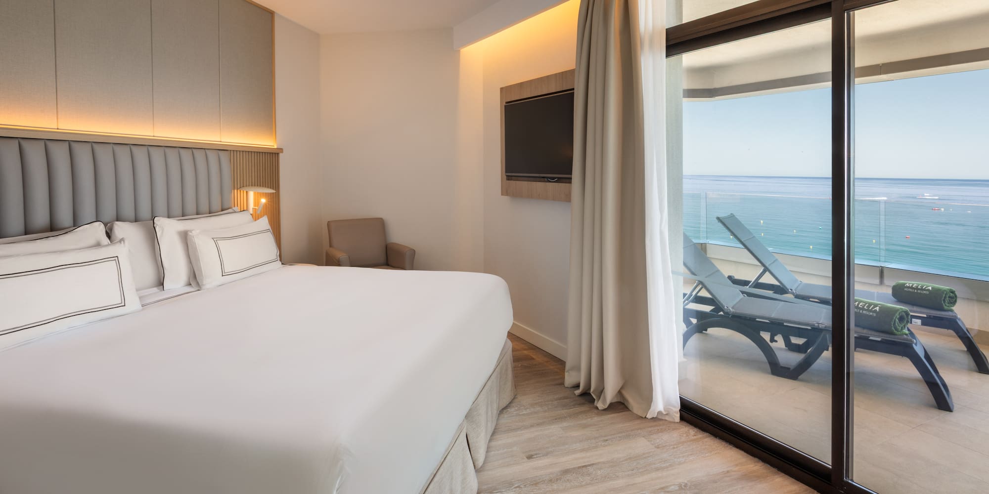 a bedroom with a large bed and a glass door