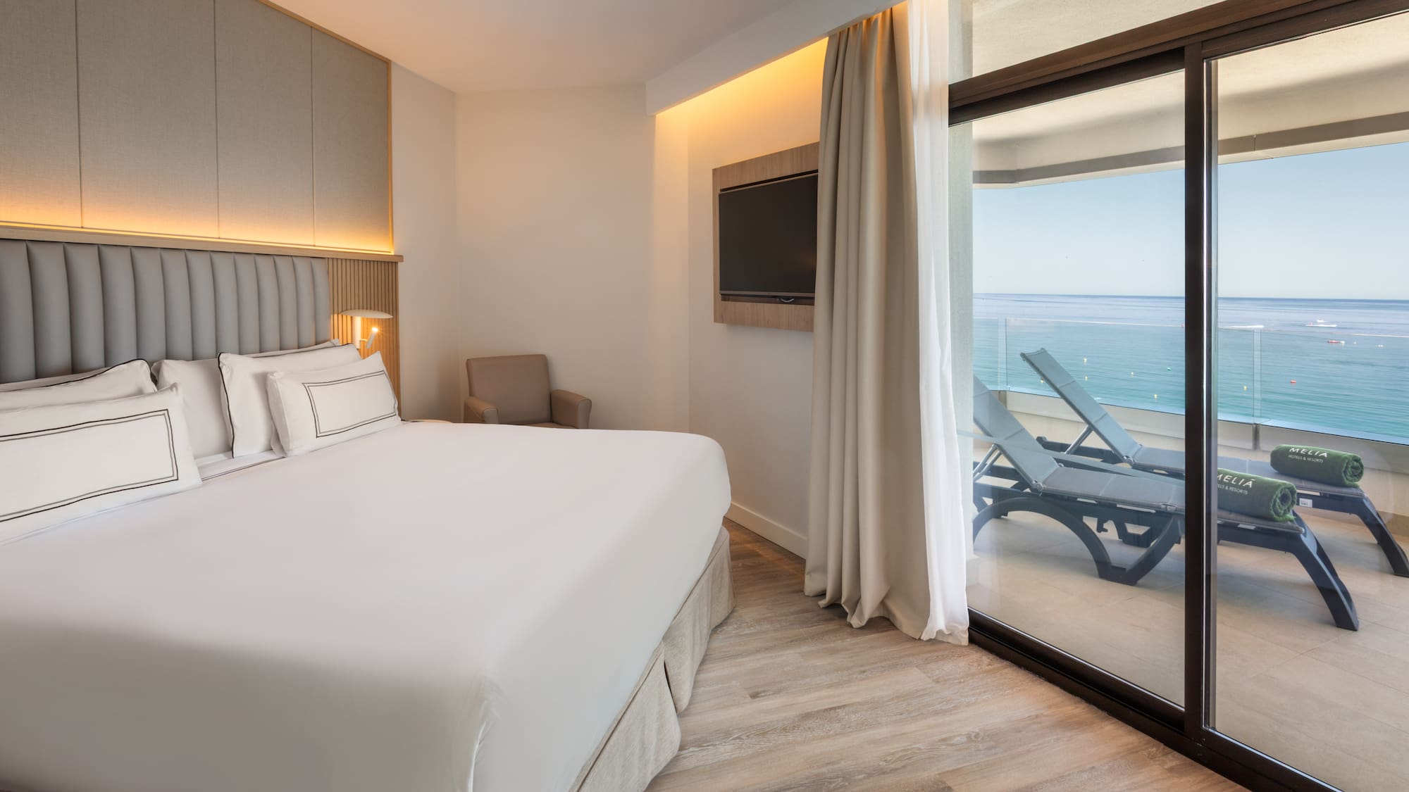 a bedroom with a large bed and a glass door