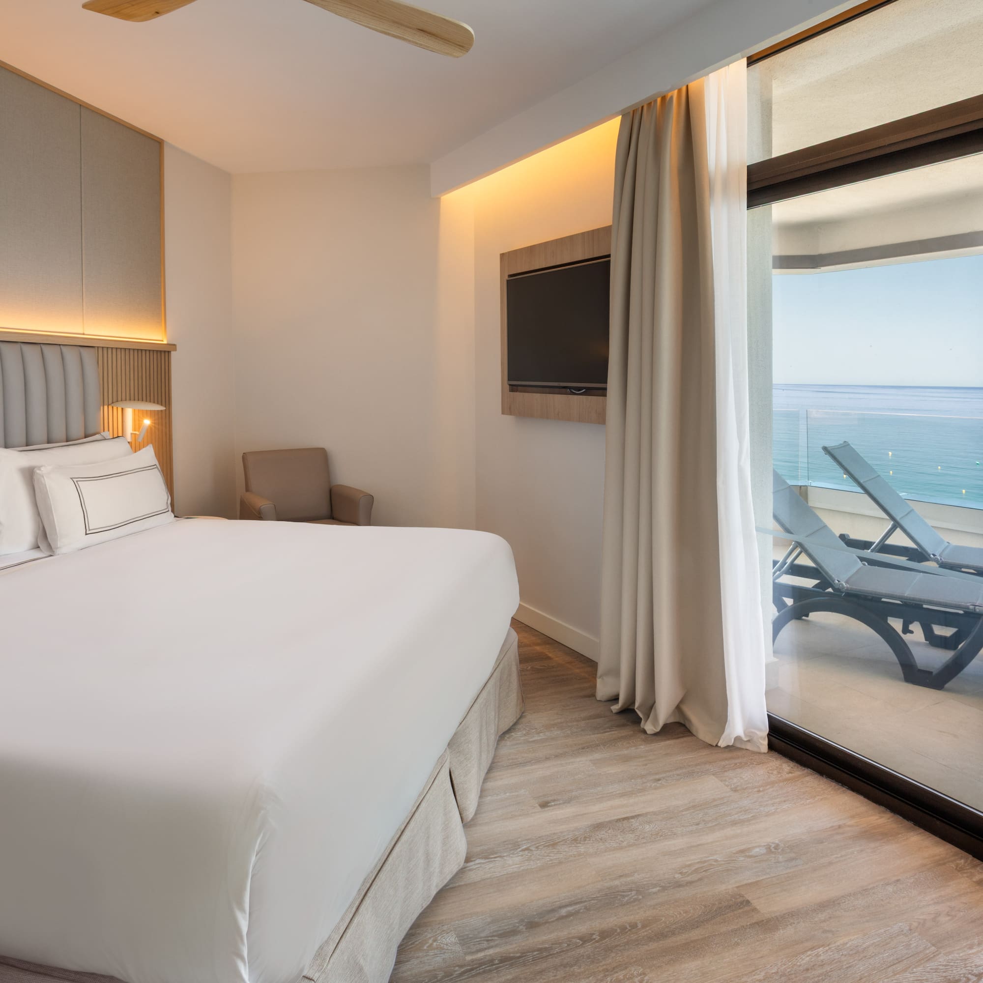 a bedroom with a large bed and a glass door