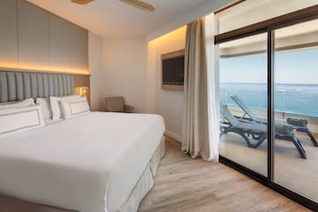 a bedroom with a large bed and a large glass door