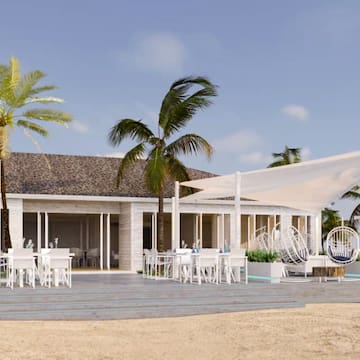 a building with palm trees and a white tent