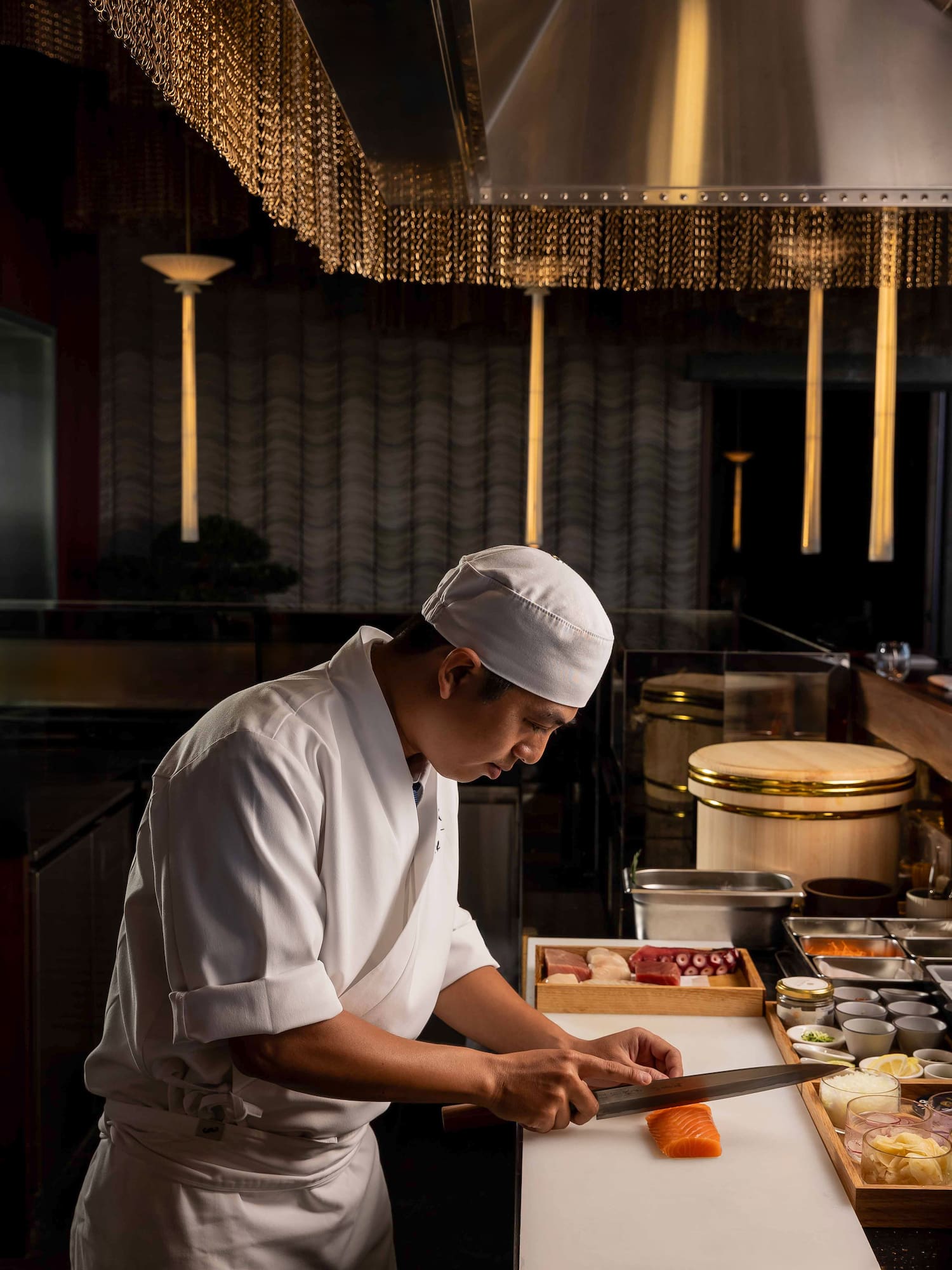 a man in a chef's uniform cutting food
