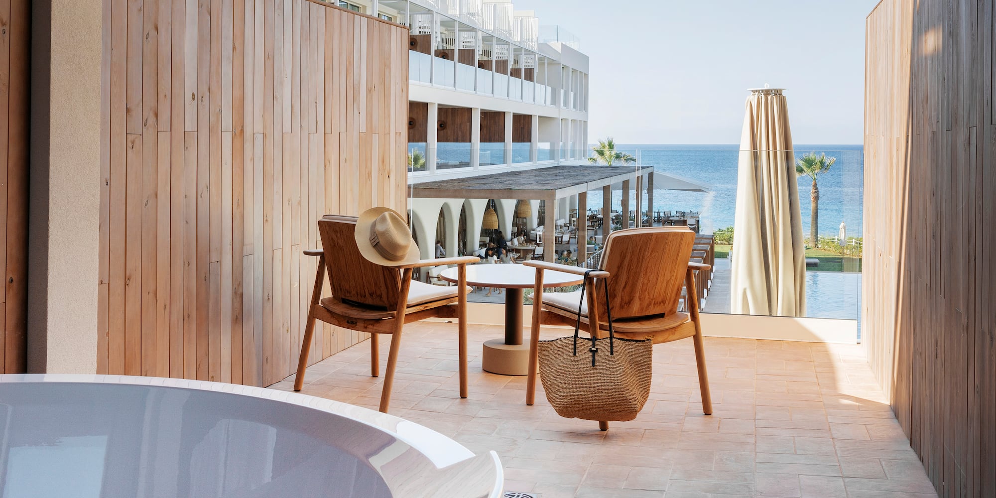 a chair and table on a patio with a body of water in the background