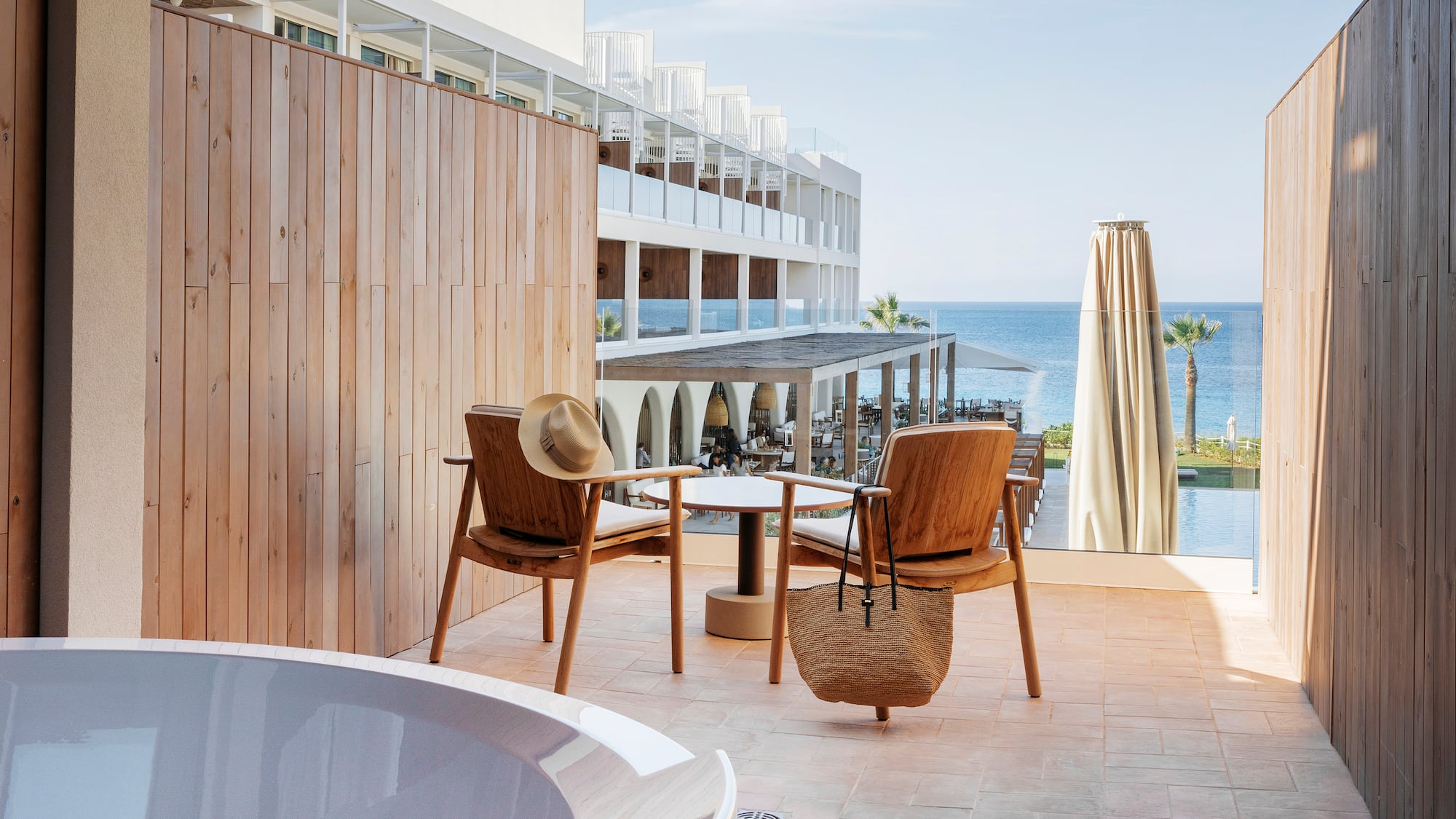 a chair and table on a patio with a body of water in the background