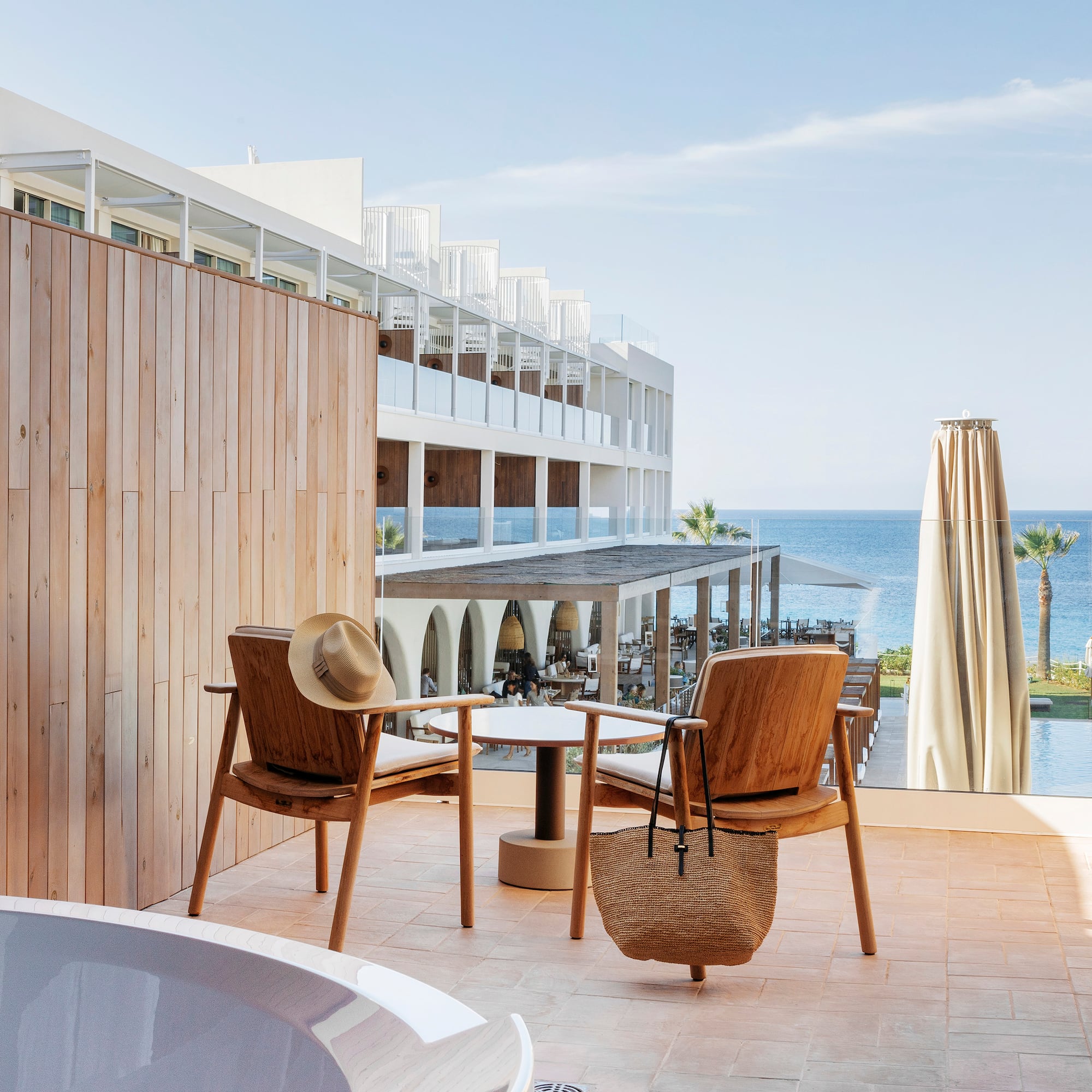 a chair and table on a patio with a body of water in the background