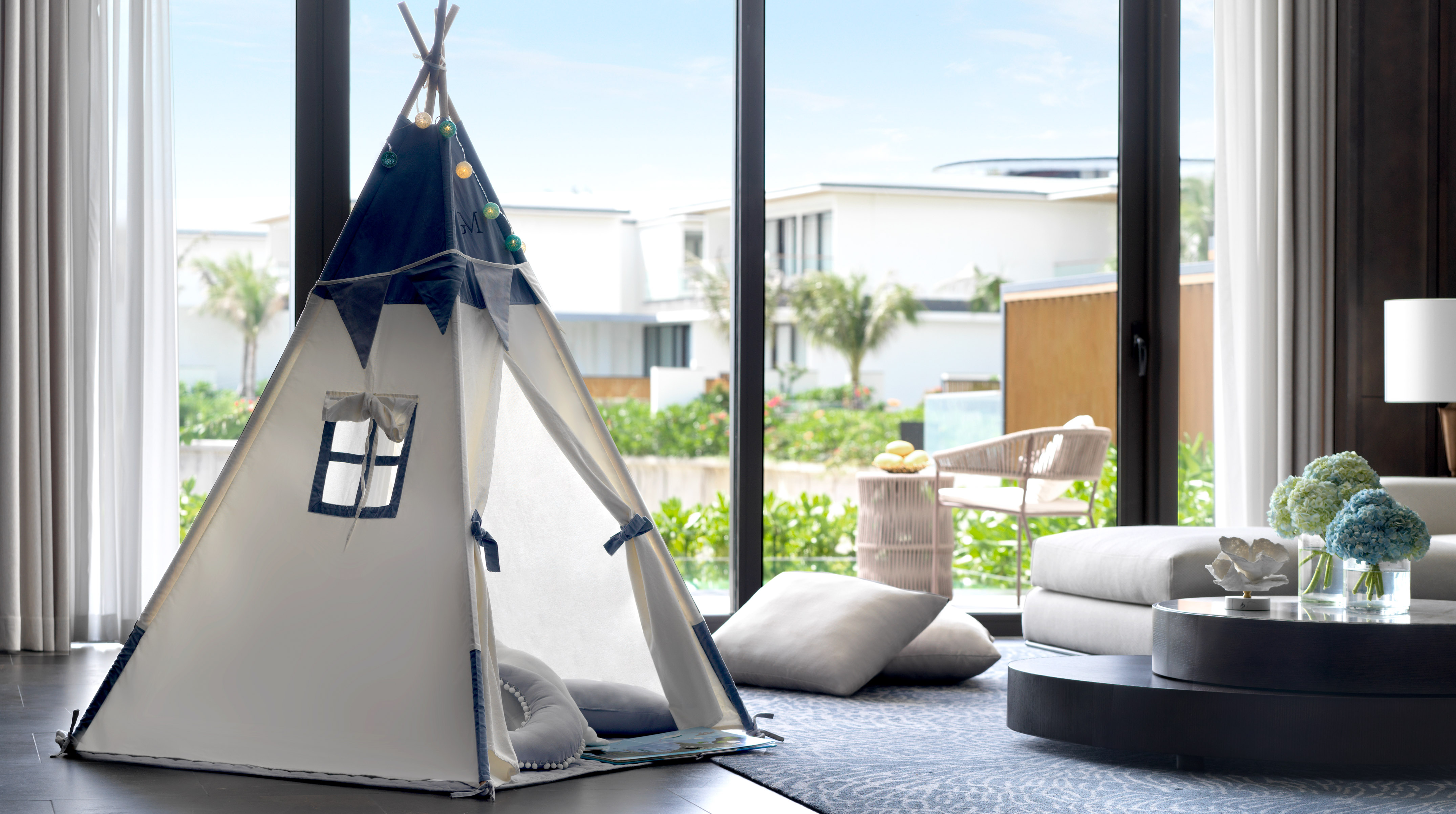White and blue children's play teepee in a modern living room with resort view.