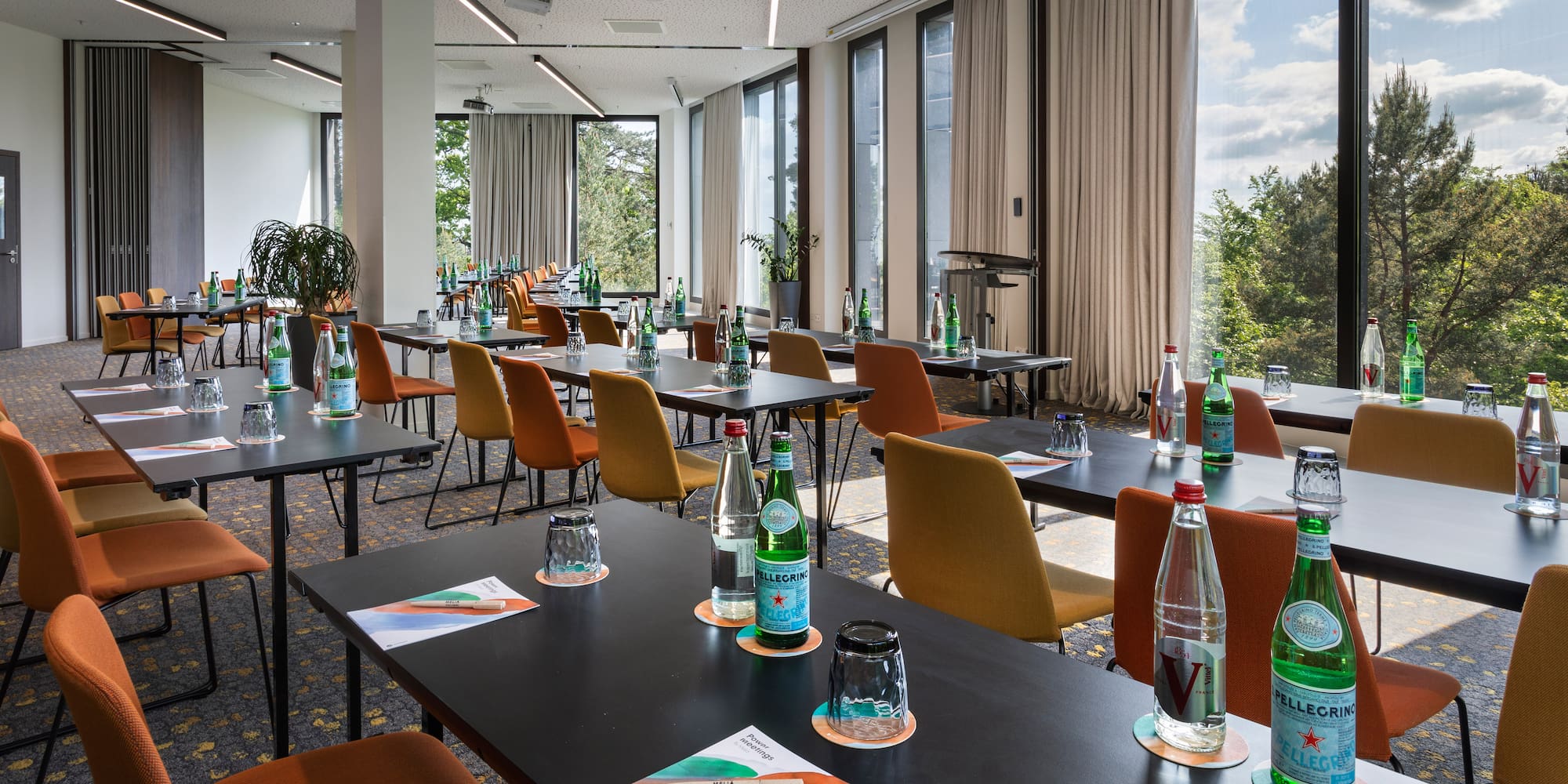 a room with tables and chairs and bottles of water