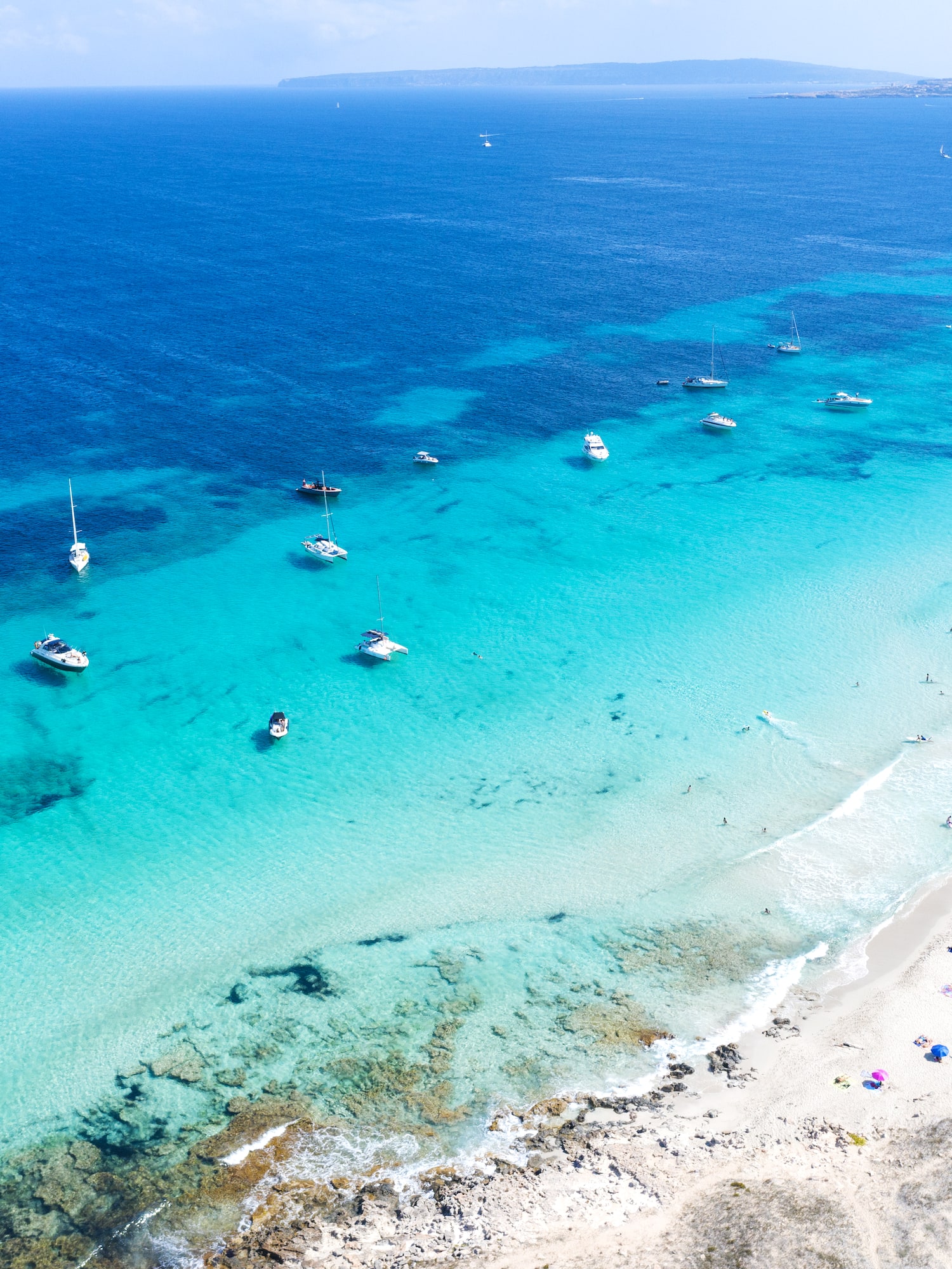 a beach with boats in the water
