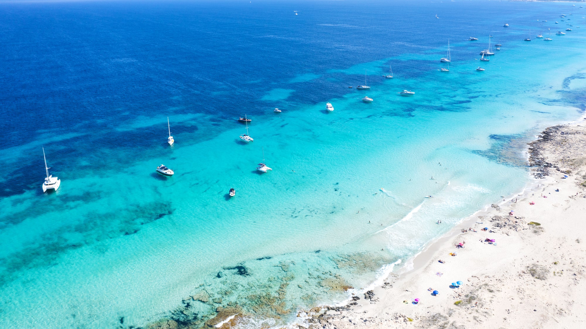 a beach with boats in the water